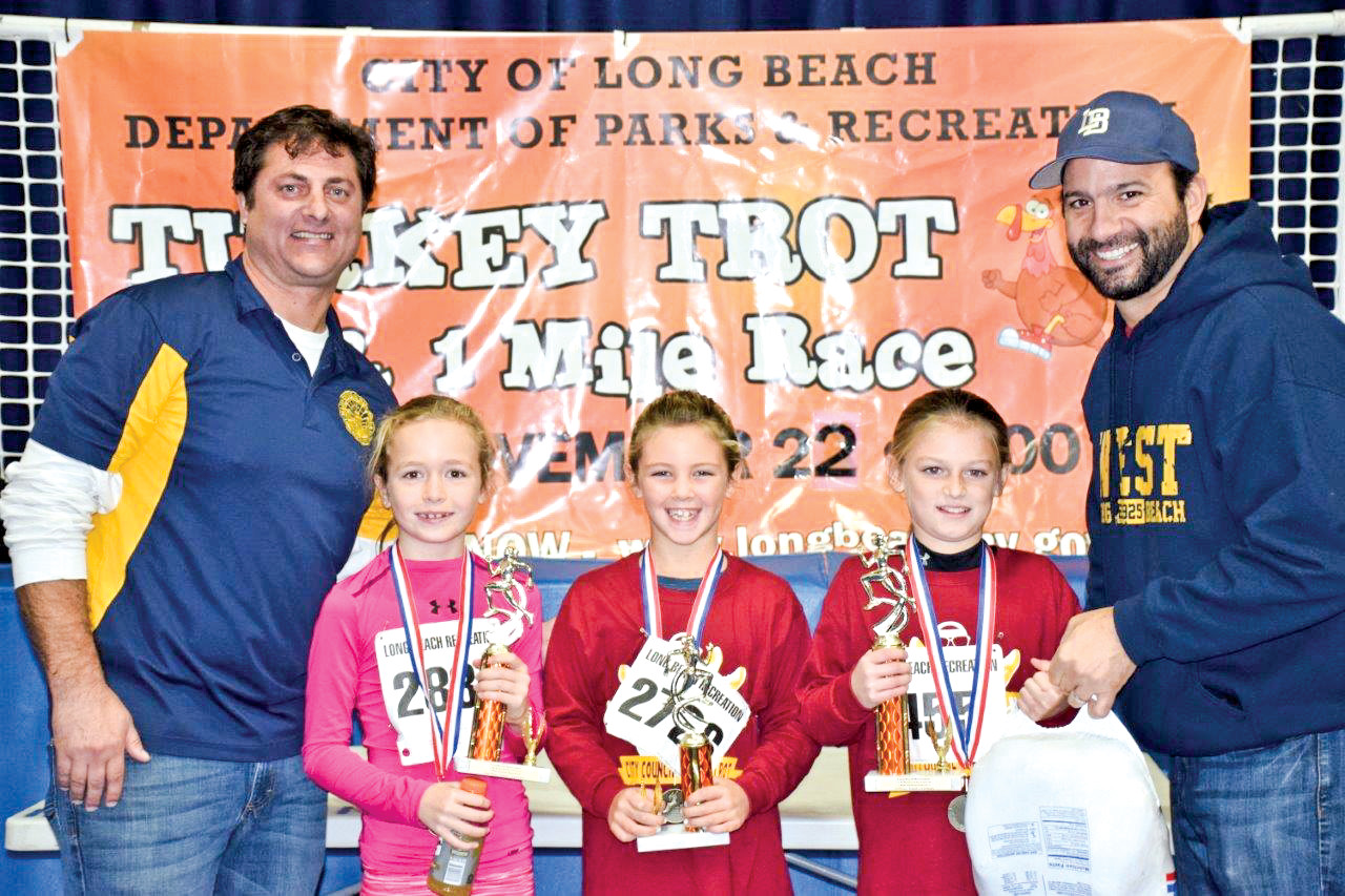 Paul Ferrante, left, assistant superintendent of the recreation department, and Councilman Anthony Eramo presented trophies to the top finishers in each race.