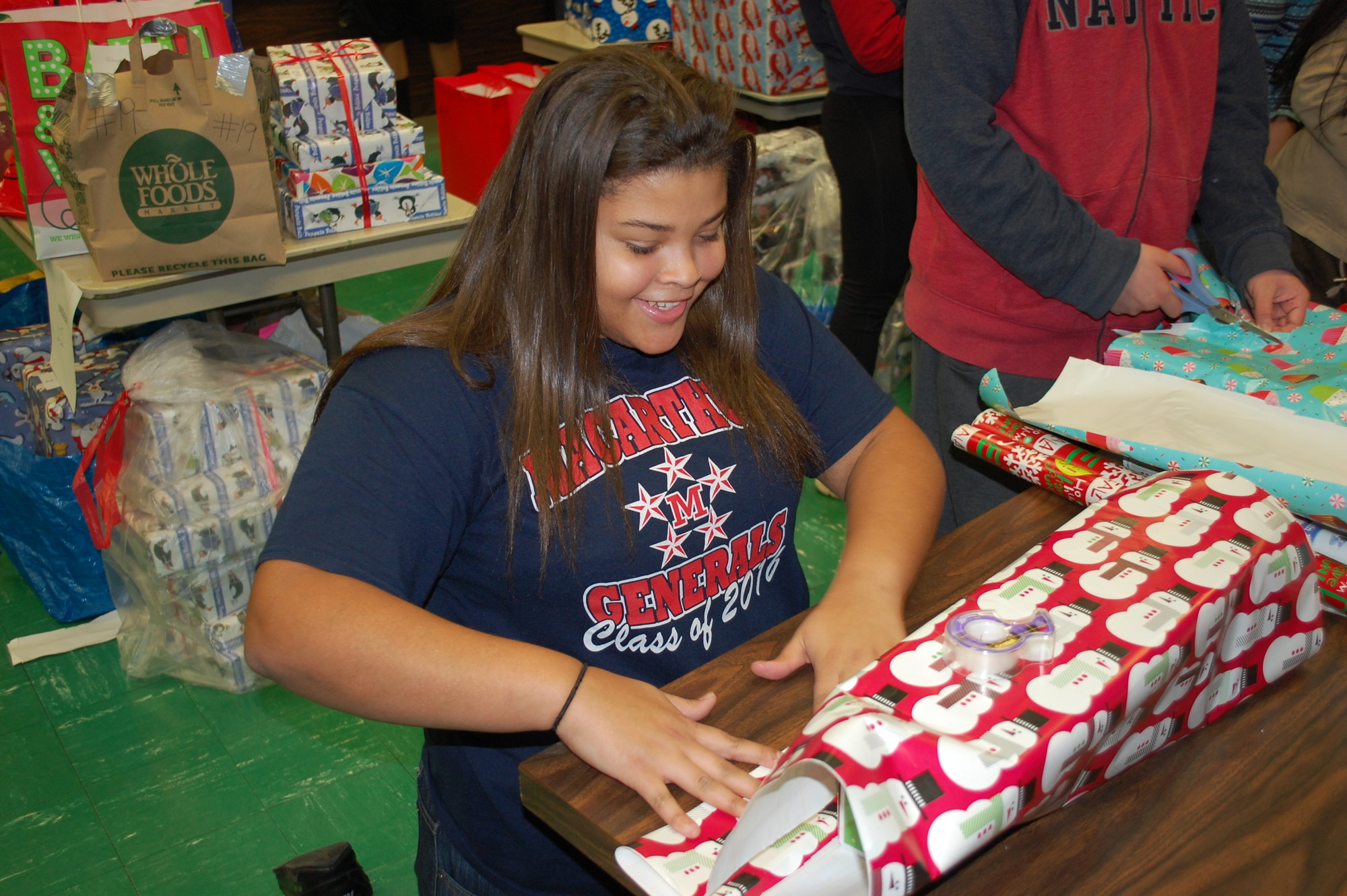 Faith Gardner, of MacArthur's World Language Honor Society, helped to wrap the presents.