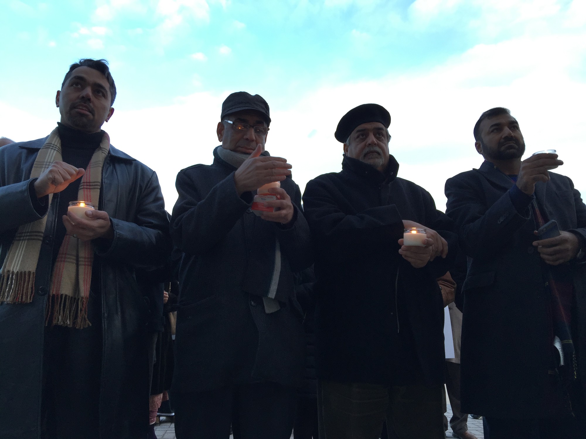 Zia Qureshi, far left, Talib Sheikh, Soni Dasghair and Atiq Qabari with their lit candles at the rally.