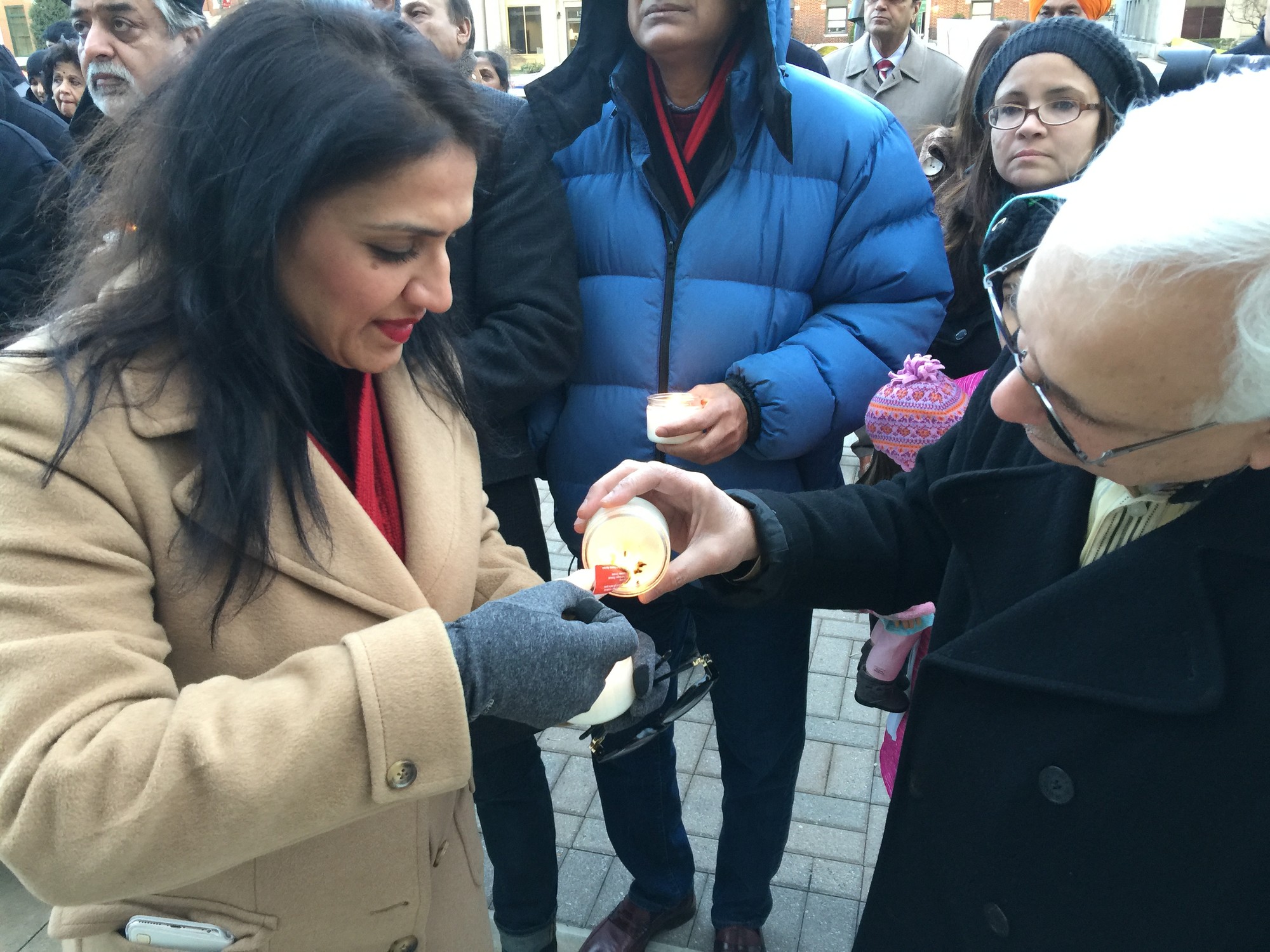 Jaweria Mirza, left, helped Dr. Tamkeen Ahmed light his candle before the ceremony began.