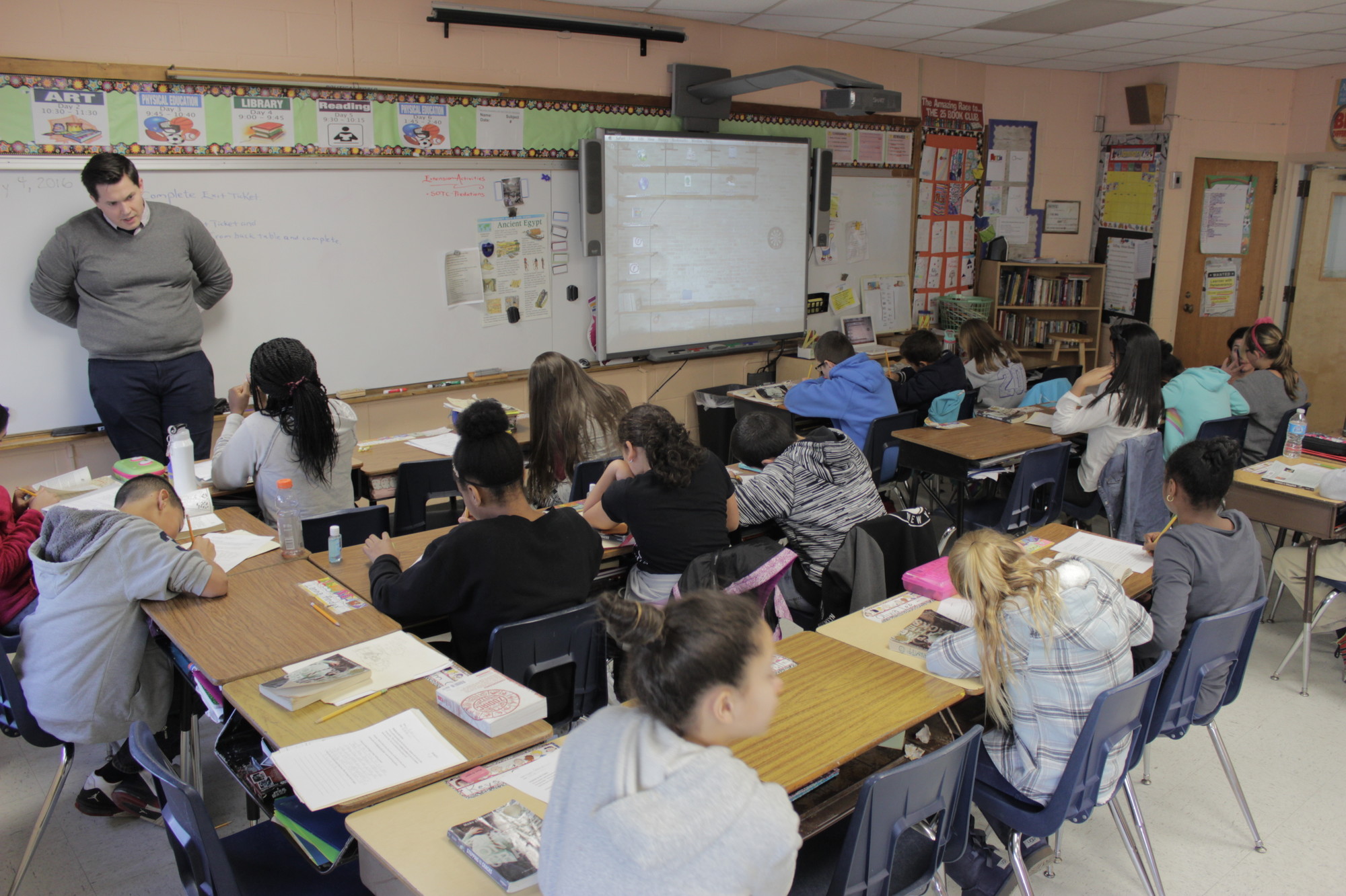 Sixth-graders in Joe Schumpf’s class at the William L. Buck School are tightly configured in a small classroom.