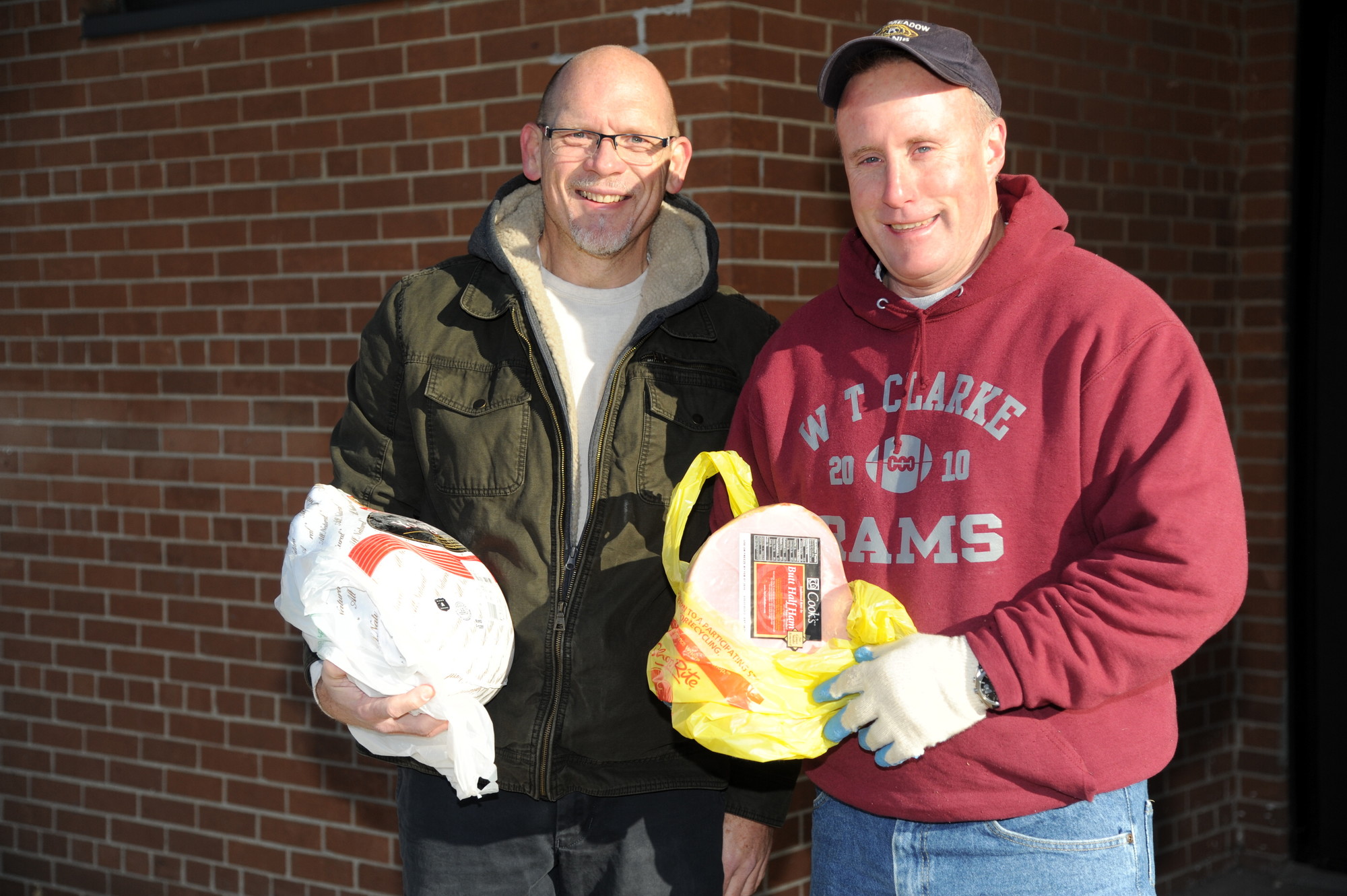 Tim Voels and Brian O’Flaherty, the East Meadow Kiwanis Club president, put together holiday baskets for families in the community, complete with turkey and hams, this weekend at W.T. Clarke High School.