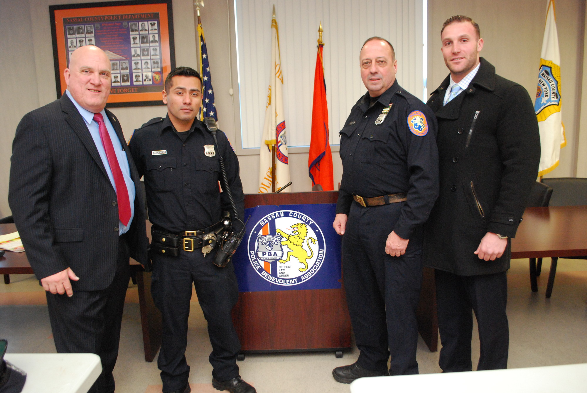 Jimmy Carver, president of the Police Benevolent Association, far left, congratulated 5th Precinct officers, Luis Ascenscio, James Schuerlein and Eban Marro, who helped rescue two people from a burning building in West Hempstad last Friday.