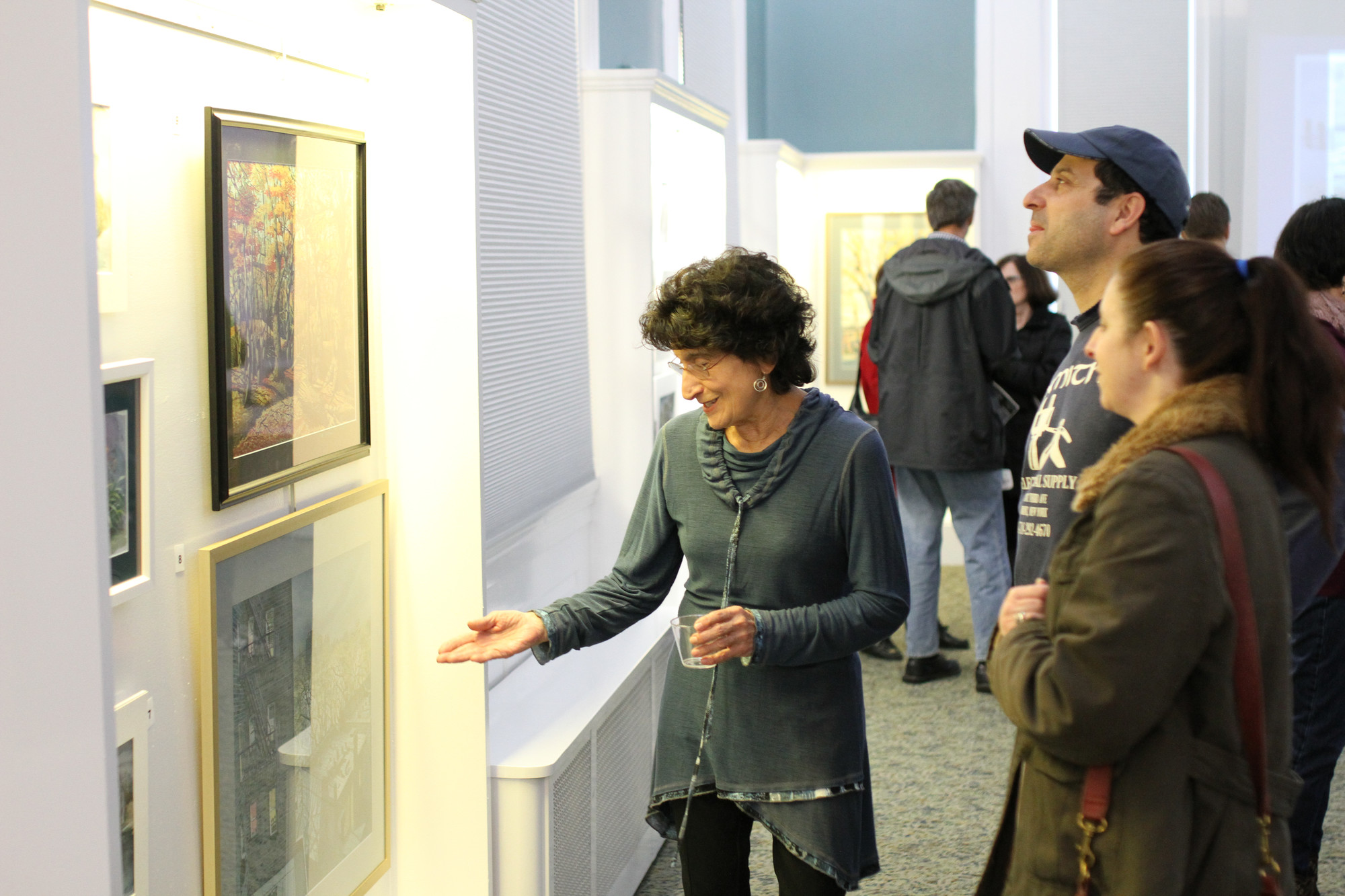 Patti Guglielmo, who worked with Bishop at East Rockaway High School, shows her son, Michael, and daughter-in-law, Corey, Bishop's artwork.