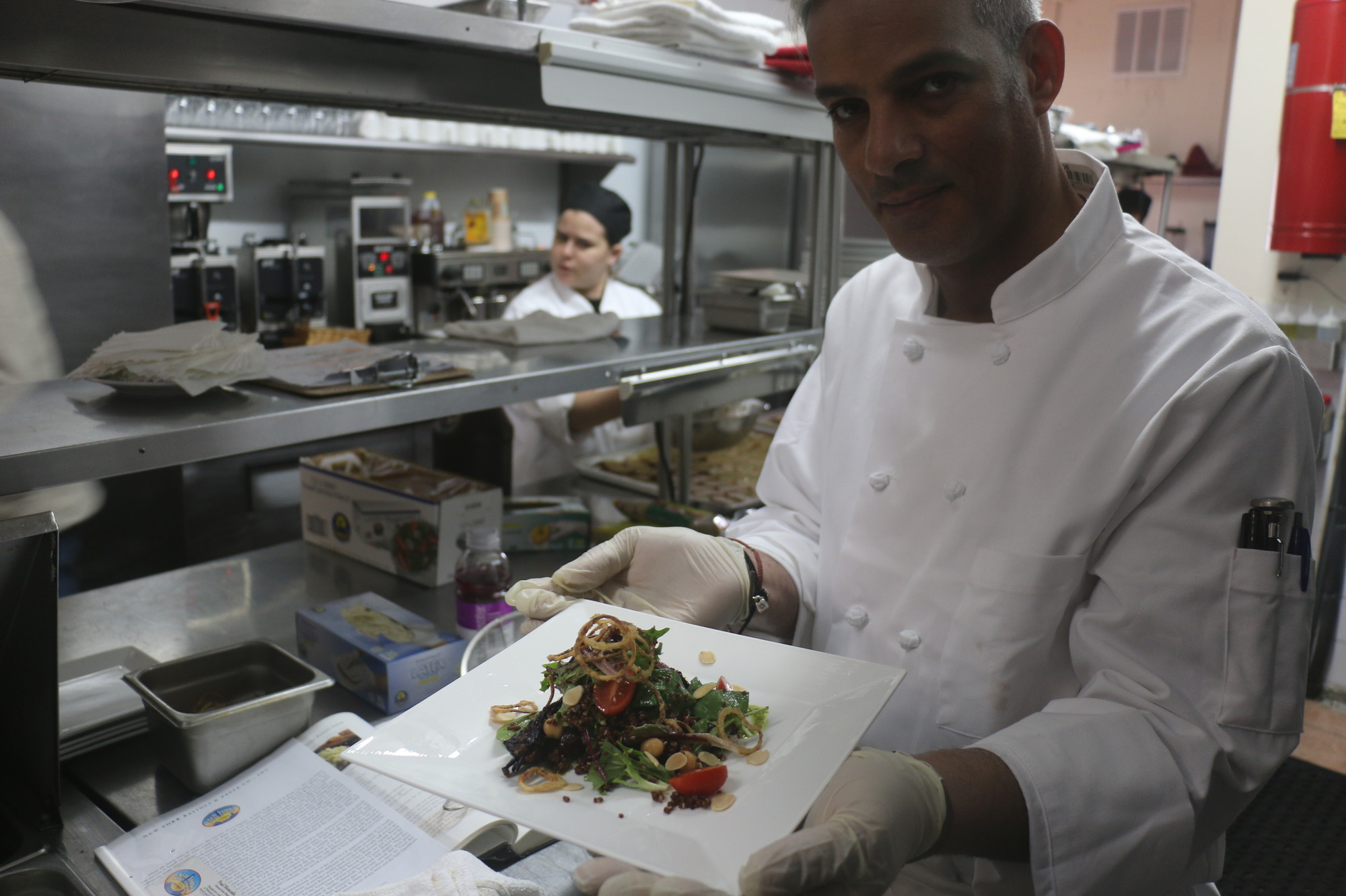 Owner Raed Jallad displayed a salad he topped with fried shallots and almonds roasted in-house.