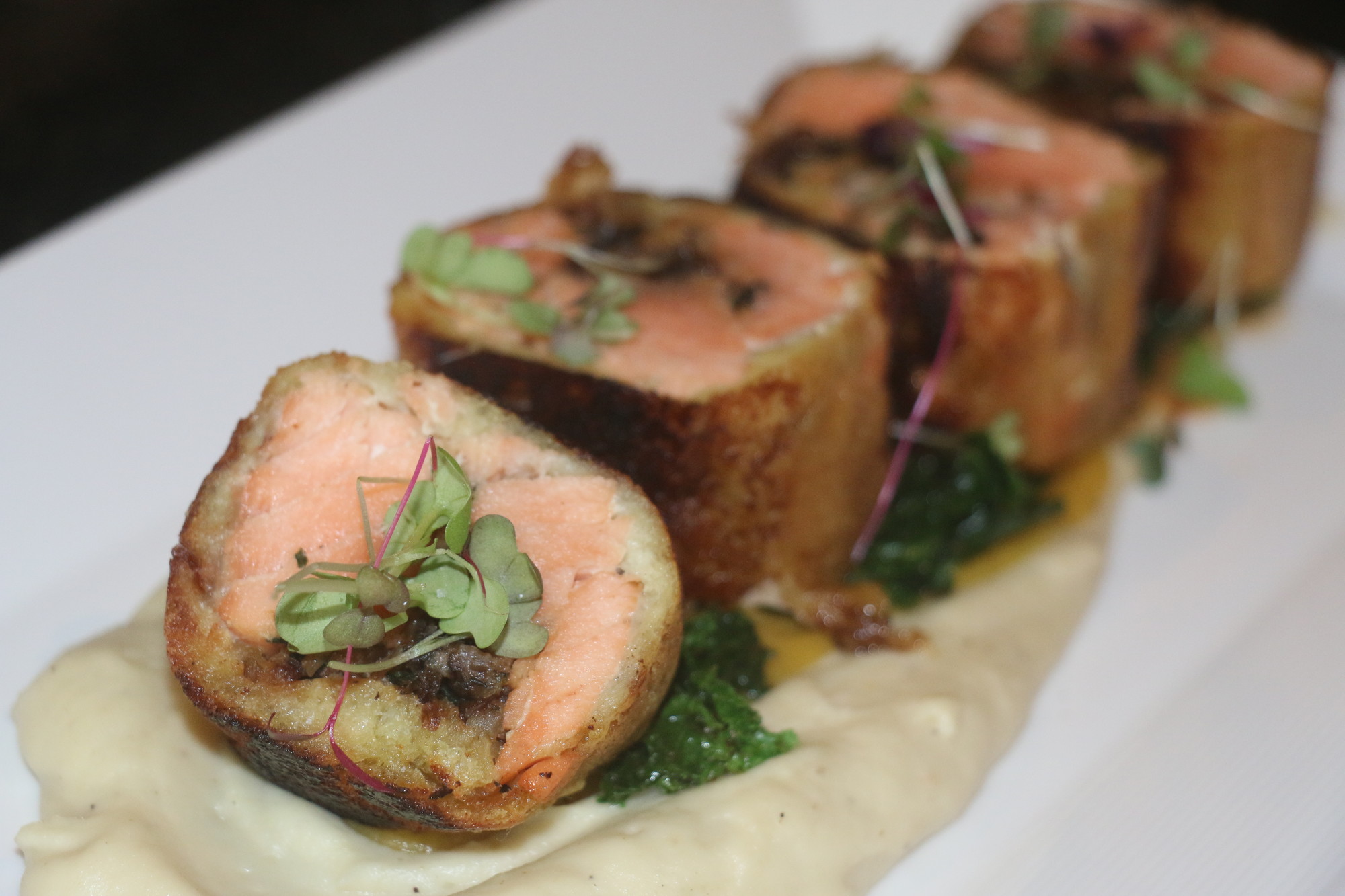 Brioche-wrapped salmon and wild mushrooms glazed with honey Dijon mustard is one of Jallad’s signature dishes.