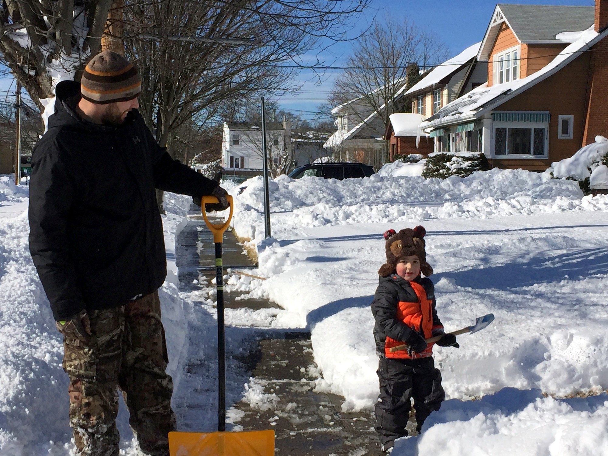 On Sunday morning, William Mattia, left, of East Rockaway, got some help with clearing the sidewalk from his son, Nicholas, 2.