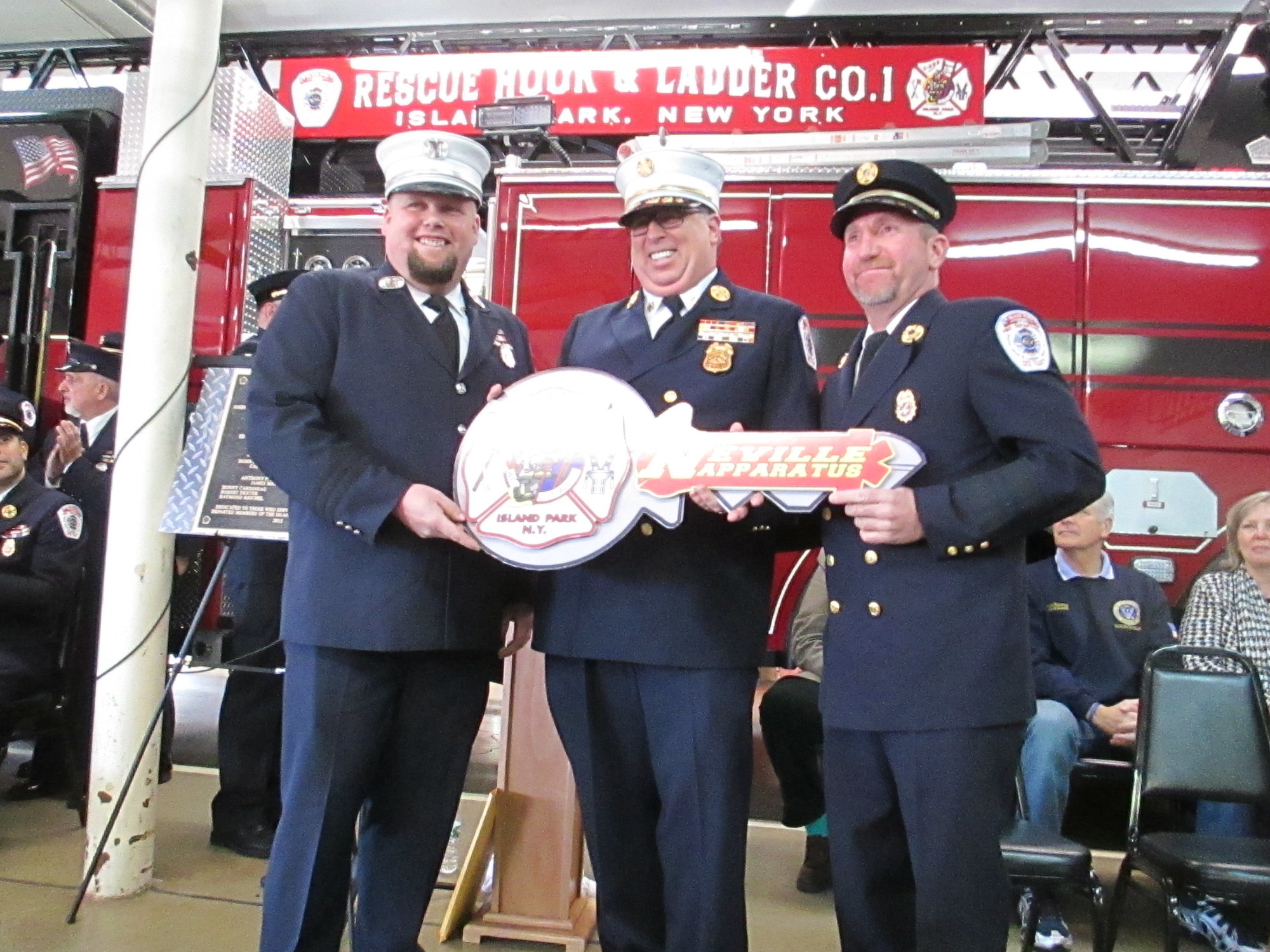 Fire Department Officers Capt. Donny Cardineau, Chief Edward Madden and Lt. Jimmy Ruzicka Jr. with the “key” to the new Ladder 223 firetruck. (Barbra Rubin-Perry/Herald)