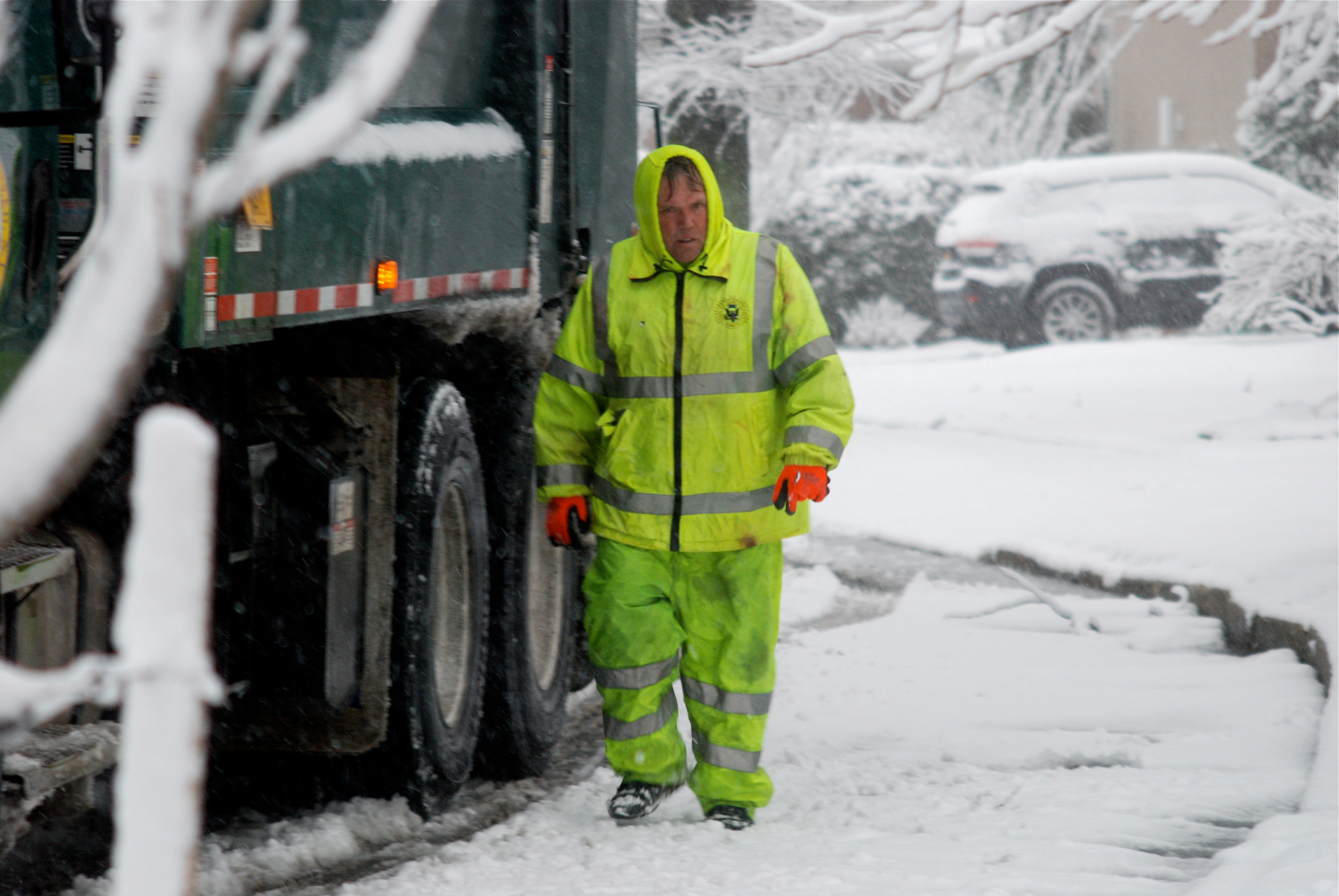 Billy Miller, a Town of Hempstead sanitation worker, collected trash amid the snowstorm on Friday morning.