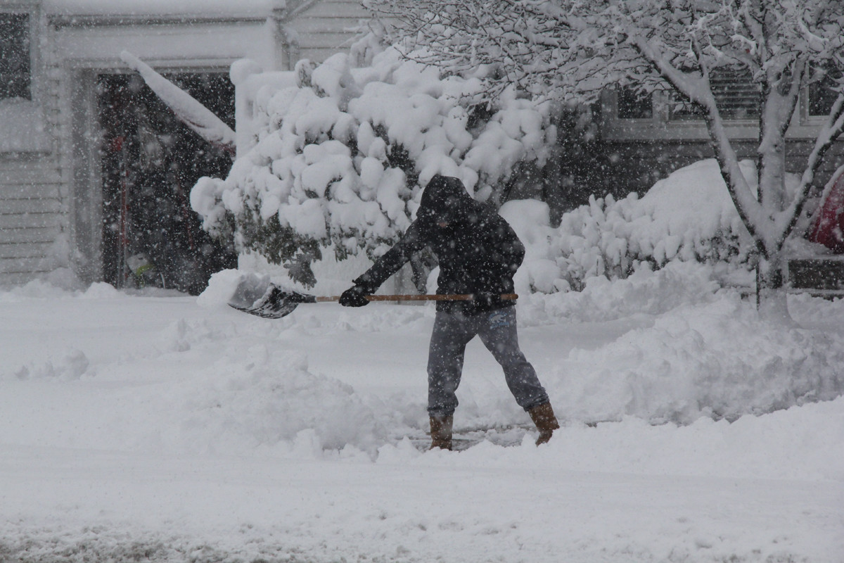 Lauren Hartmann, of Seaford, struggles to remove the snow in front of her house on Seaford Avenue.