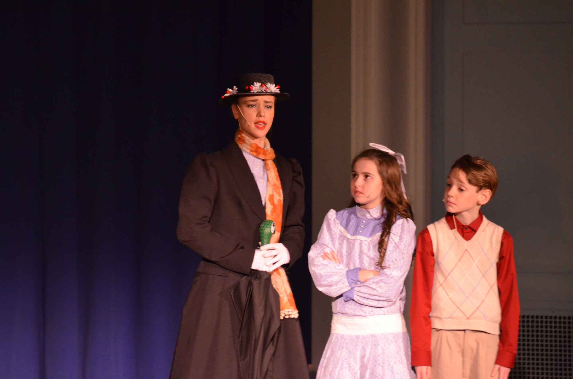 Mary Poppins played by Katharine Calabrese with Jane Banks played by Grace McNally and Michael Banks played by Brennan Donovan.