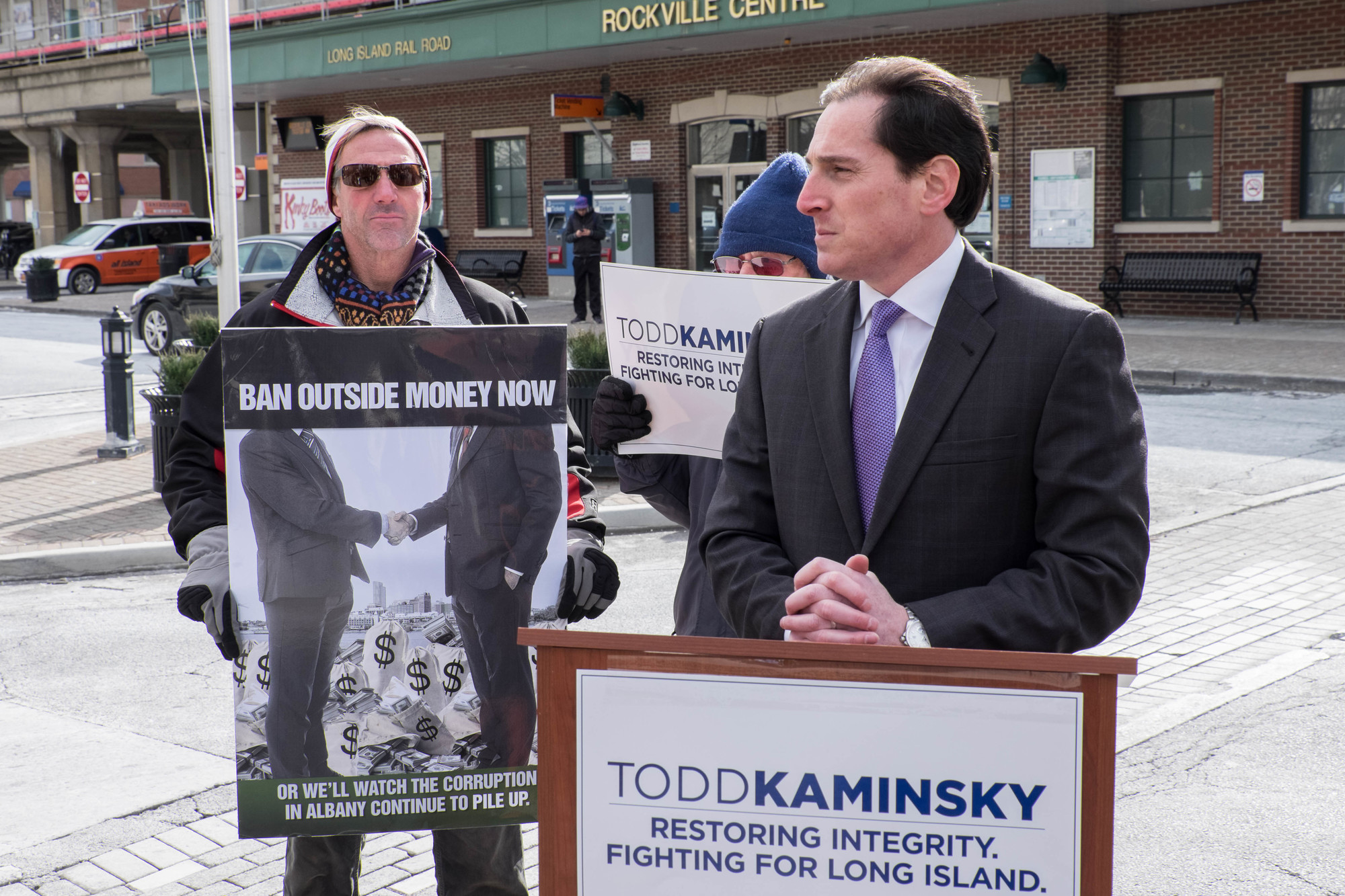 Todd Kaminsky, right, with supporters outside of Dean Skelos’s former office in Rockville Centre, promised he would put forward legislation to ban outside income for legislators on his first day in the Senate.