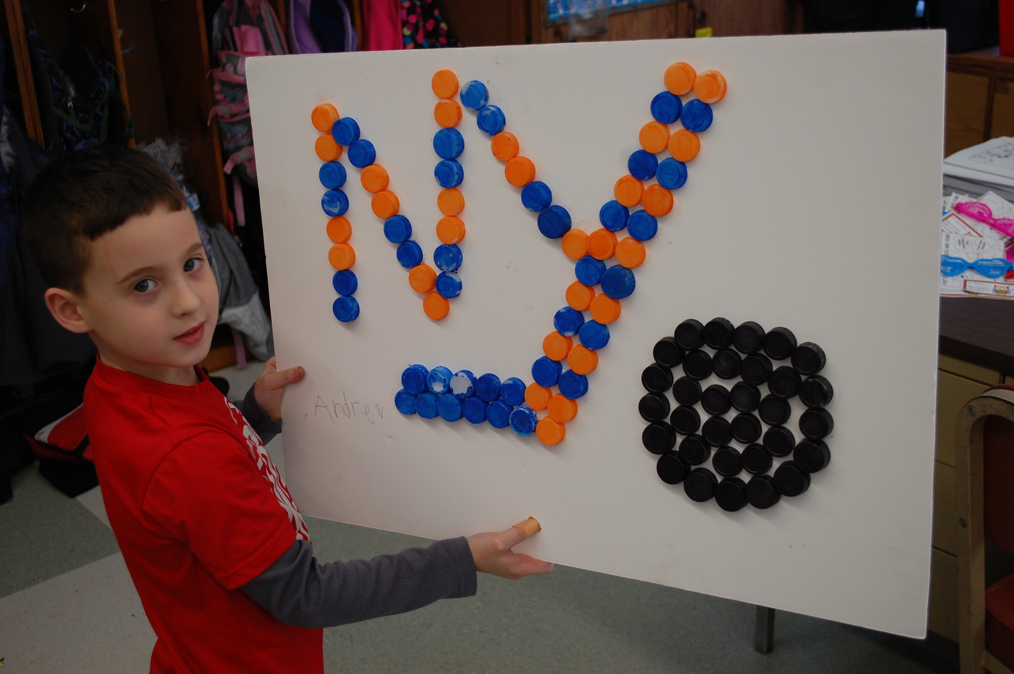Seaford Manor School kindergartner Andrew Firth made the logo of his favorite hockey team, the Islanders, with 100 bottle caps that he painted.