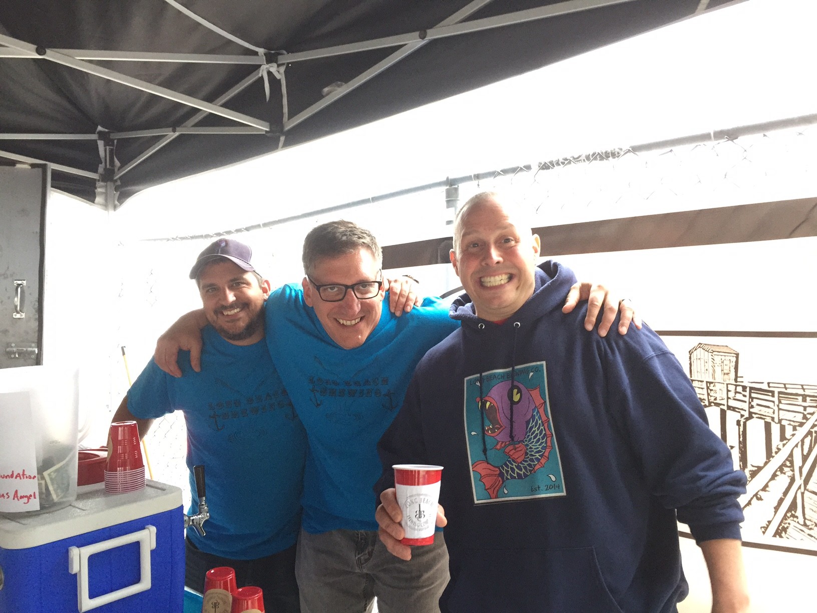 Patrick Harten, left, Brett Blau and Dan Scandiffio served their beer at Unsound’s art show and fundraiser last June.