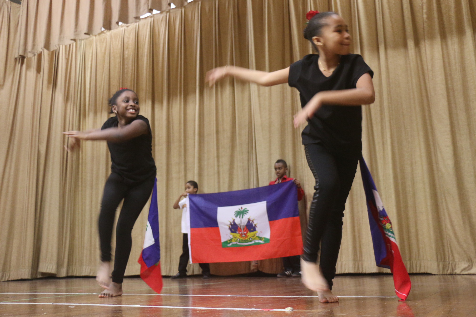 Jolina Badette, left, and Ysabel Clesca danced in front of the Haitian flag.