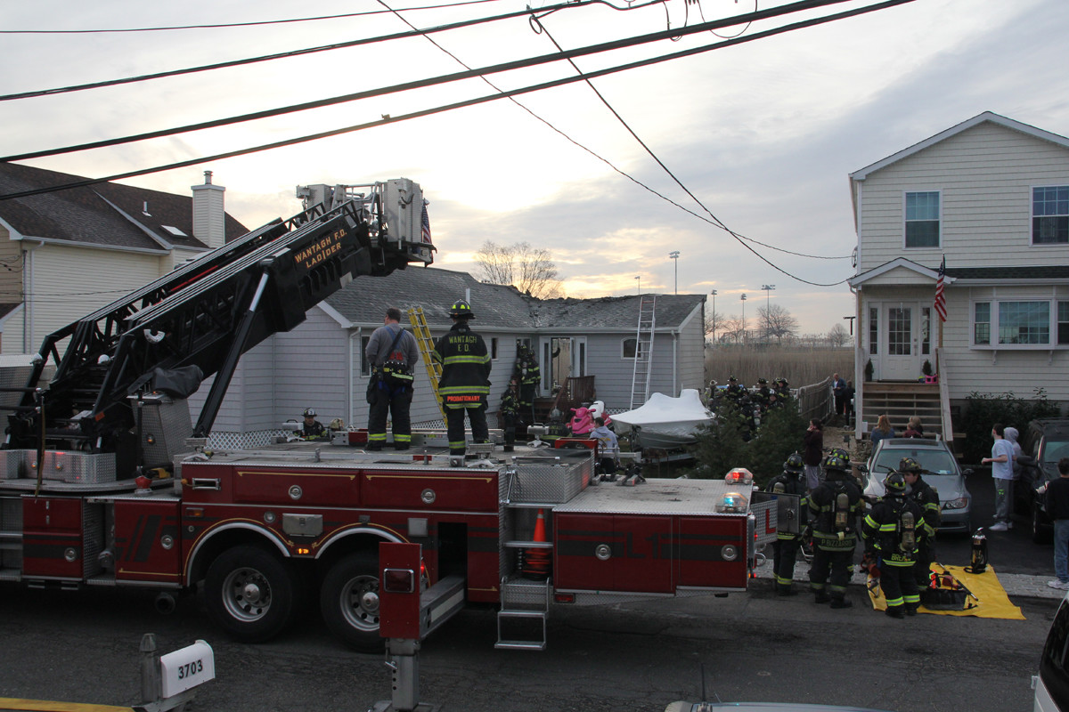 Wantagh and Seaford firefighters checked for hot spots outside a smoldering house on Somerset Drive, in the Seaford Harbor neighborhood, after it caught fire last Sunday morning.