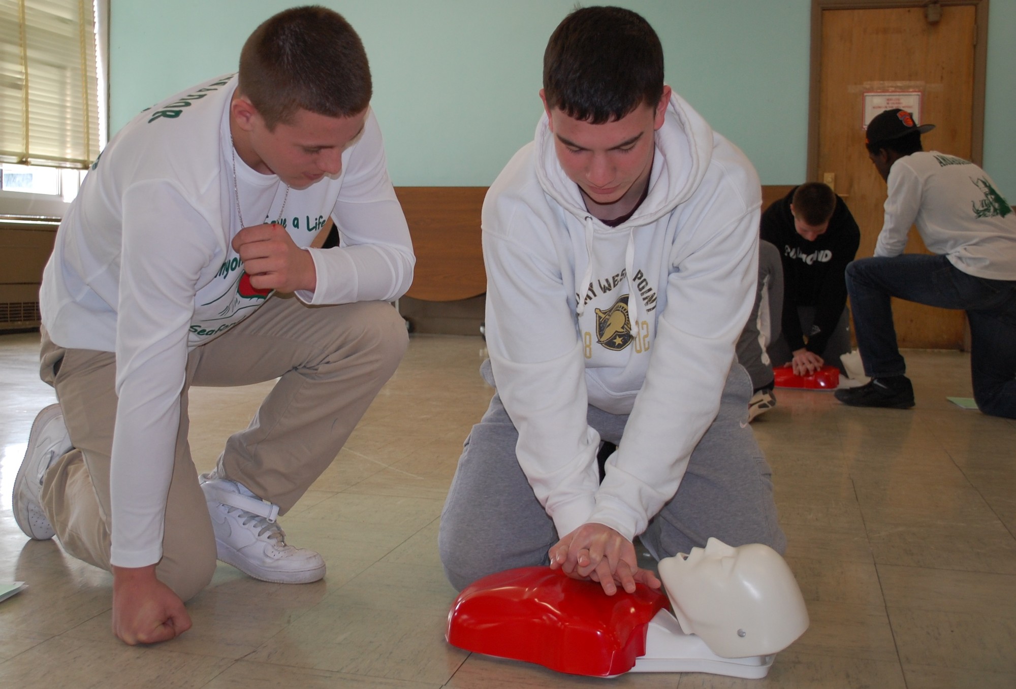 Ambassador Andrew Cain, left, a junior, showed Kevin Murphy how to do proper chest compressions when administering CPR.