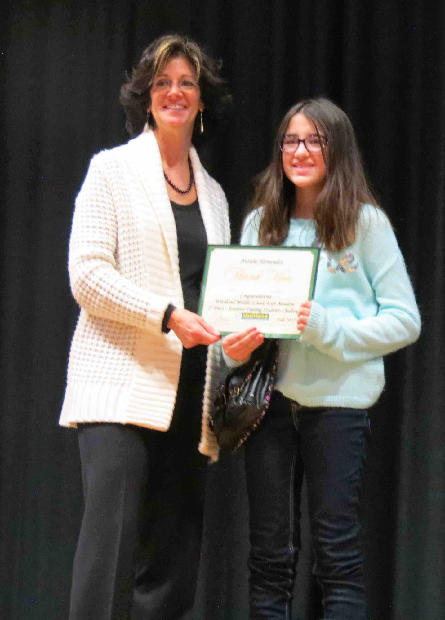 Shubin Dresner, a Woodland alumna, recognized sixth-grader Natalie Hernandez for donating the most food.
