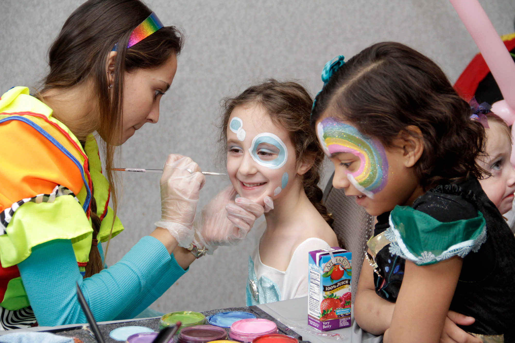 Gianna Farley, center, and Lauren Torres were happy to have their faces painted at the East Meadow Jewish Center’s “Purim Party with a Purpose” event on Sunday.