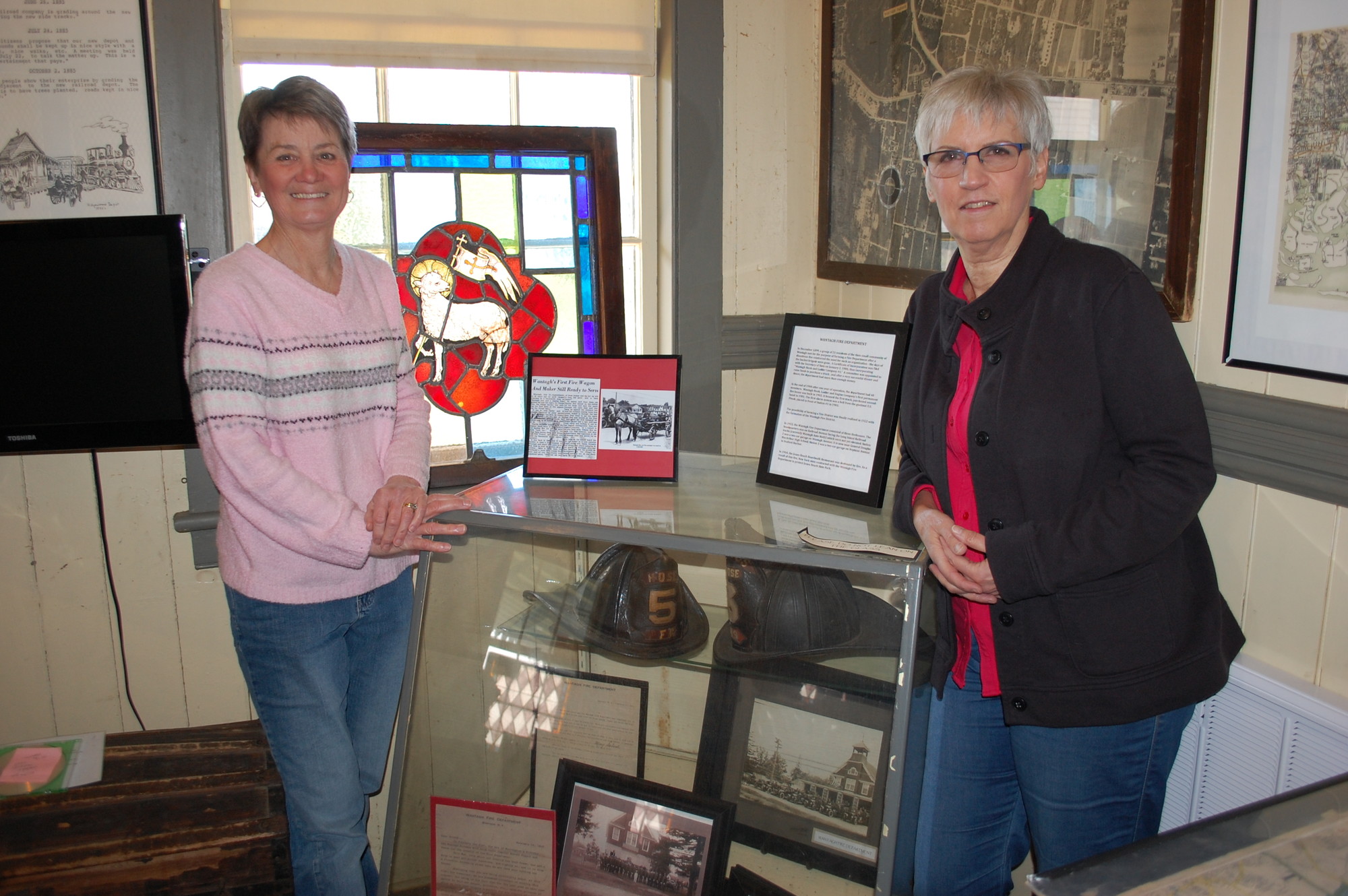 Claire Reisert and Carol Poulos with some of their favorite artifacts in the Wantagh museum.