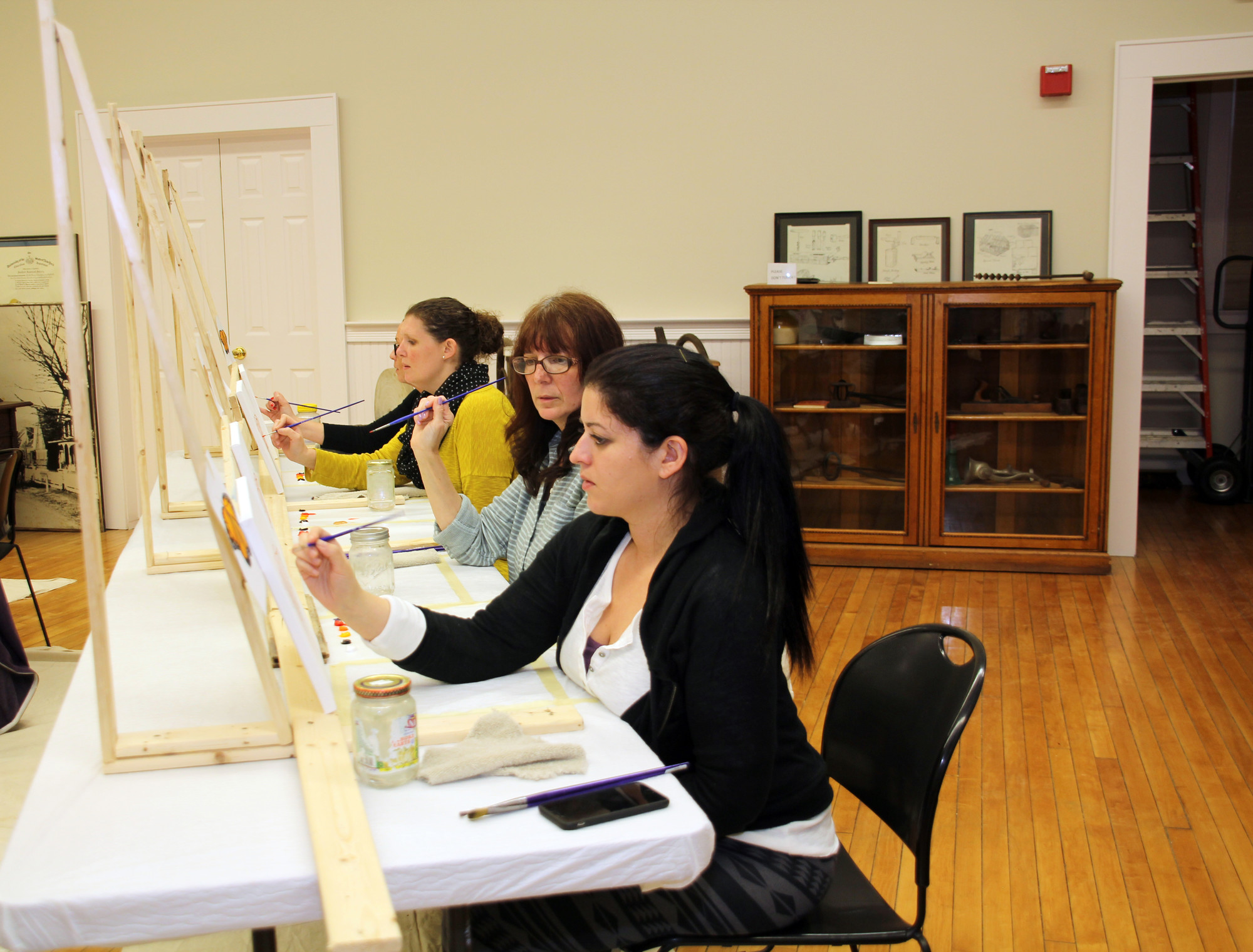 Jillian Pelliccia, foreground, Cindy Schaaf and Meghan Schaaf focused on their paintings.