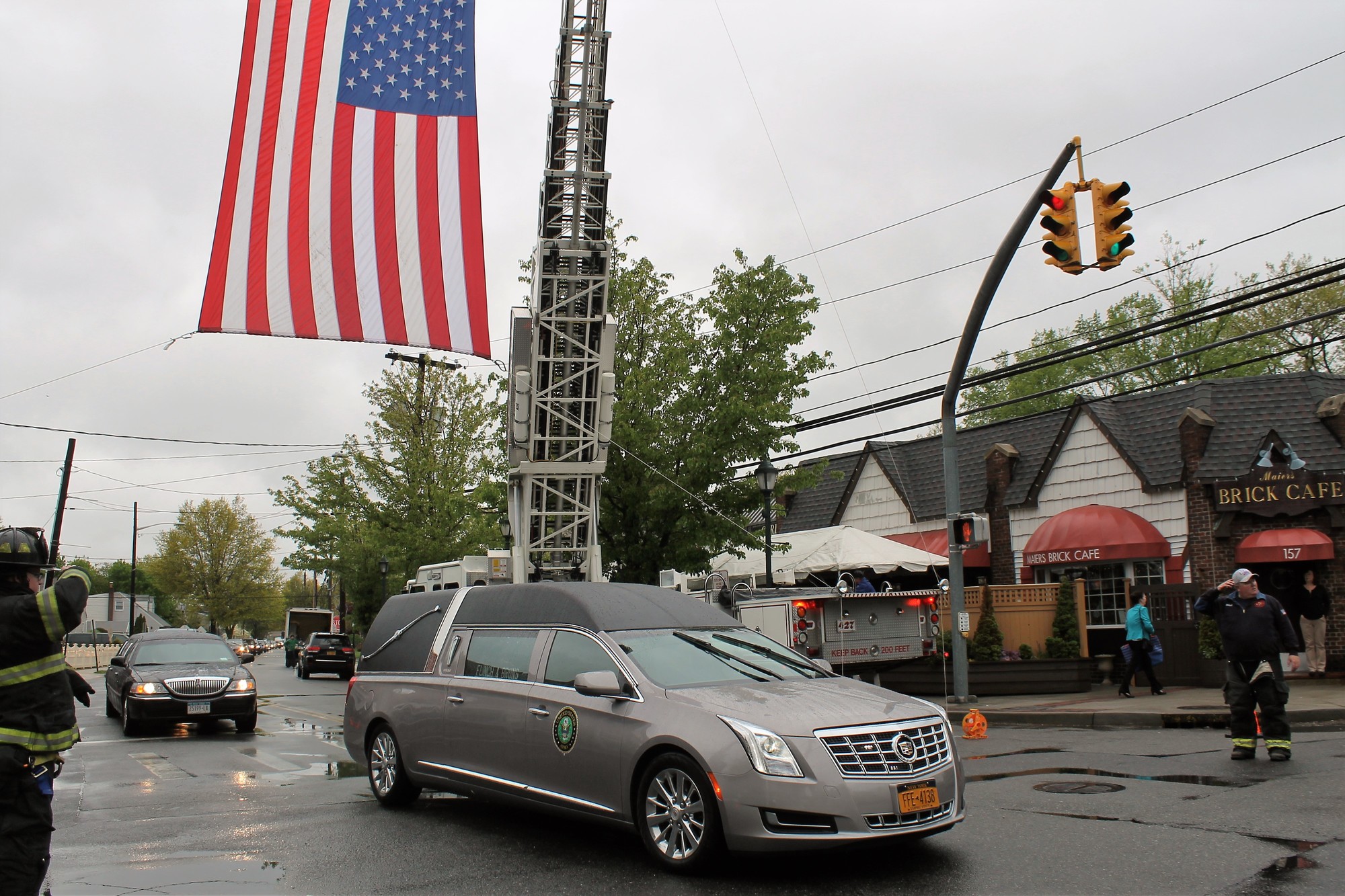 A hearse carrying Maier drove under an American flag as it passed his business, the Brick Café, on the way to the Long Island National Cemetery.
