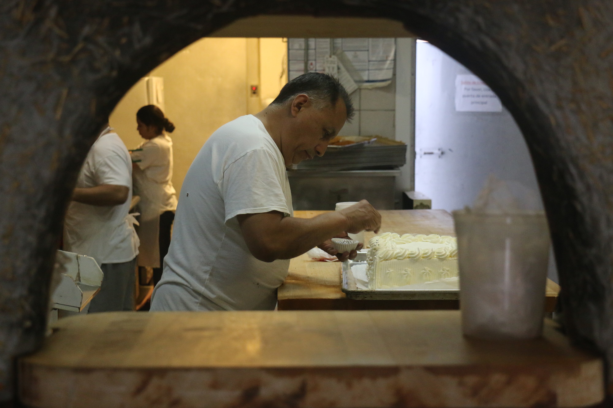 Owner Juanito Acevedo put the finishing touches on a cake.