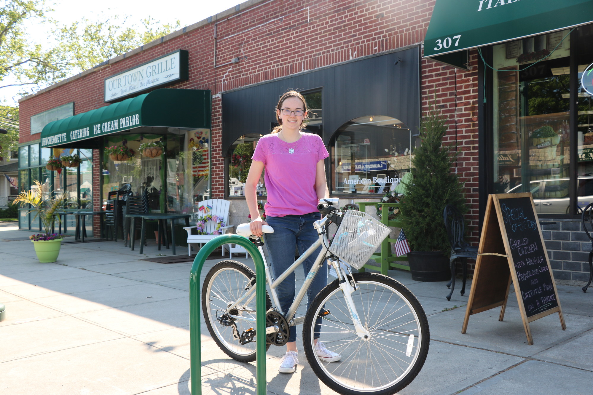 Fourteen-year-old Fiona Marren, who has raised over $1,200 for the purchase of at least 10 bike racks that will be installed on village sidewalks, with one of the racks she’d like to buy.