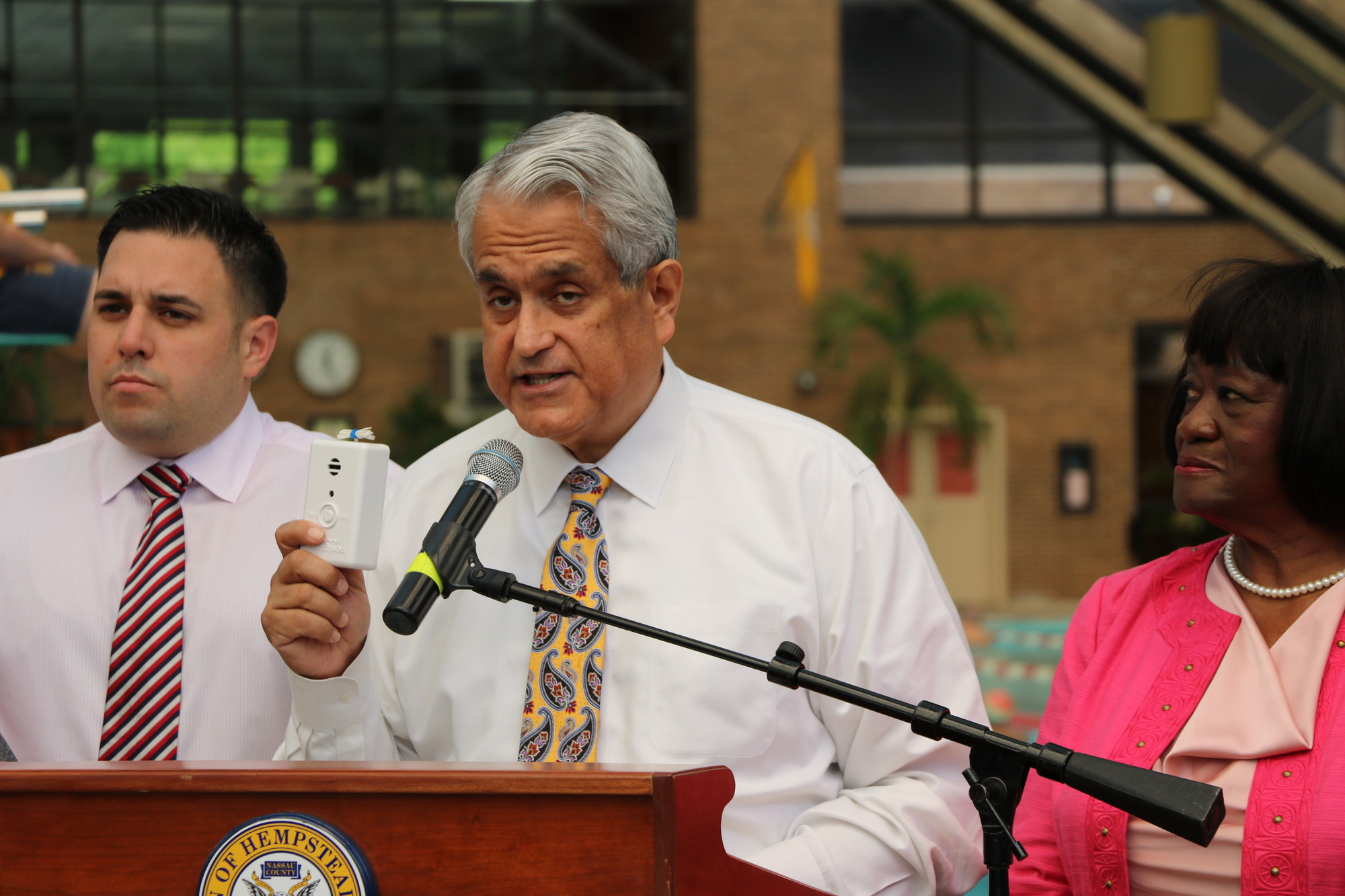 Town supervisor Anthony Santino displays remote pool alarm during a press conference last week.