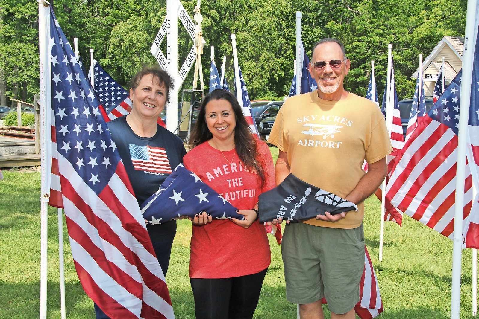 Wantagh 6-12 Association members Julie Argueta and Vivian Fitzgerald, along with Wantagh Historical Society Vice President Bob Meagher stood amongst the flags that now surround the Wantagh Museum.