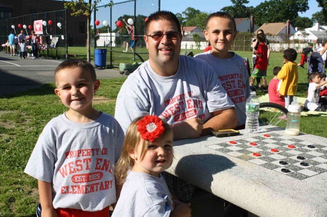 The Jaworowski family enjoyed a game of checkers at the picnic. From left: Lucas, Sofia, father Eric and Blake.