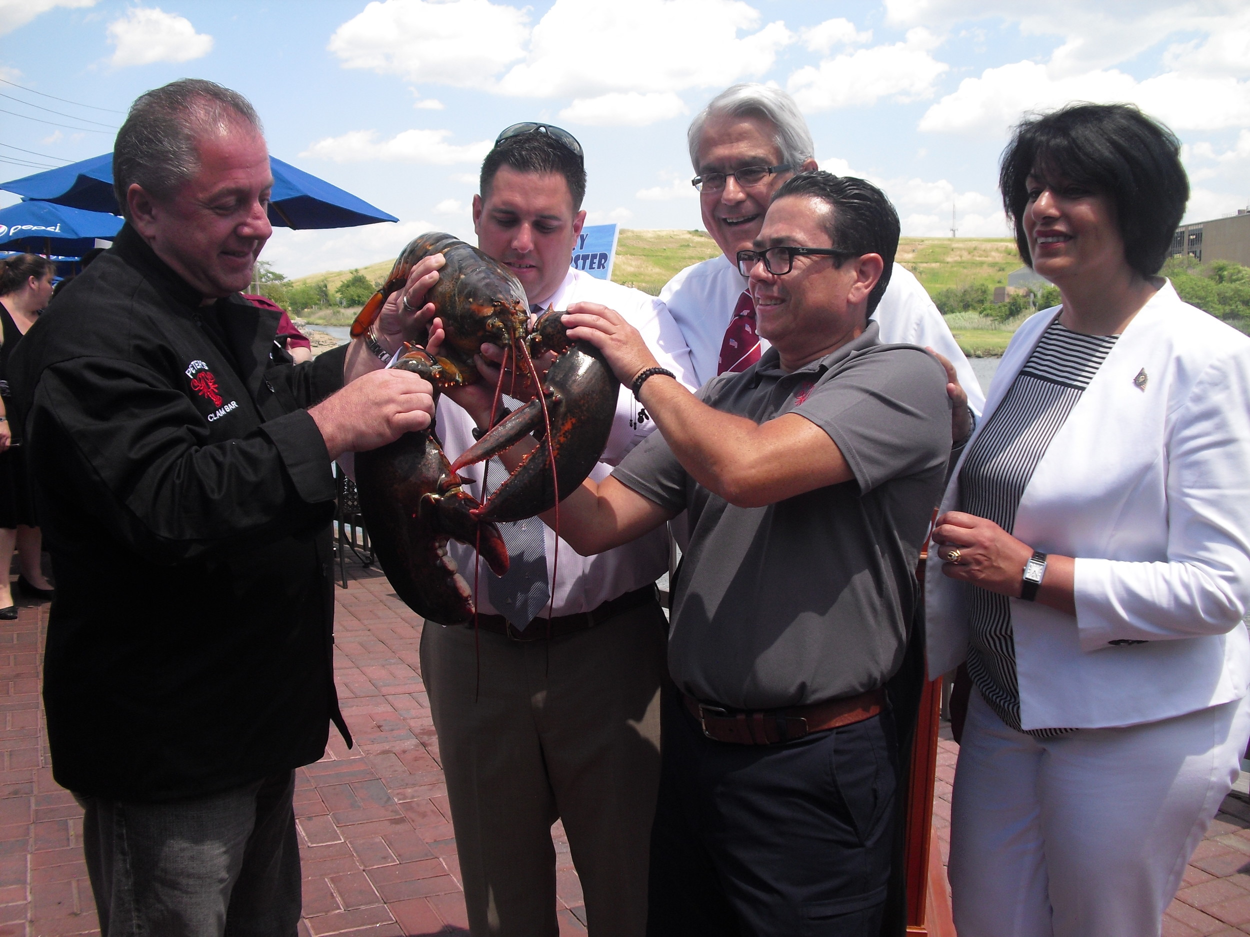 All eyes were on Larry the Lobster before his release. From left, Butch Yamali, Town Councilman Anthony D’Esposito, Supervisor Anthony Santino, Pepe Polblador and Town Clerk Nasrin Ahmad.