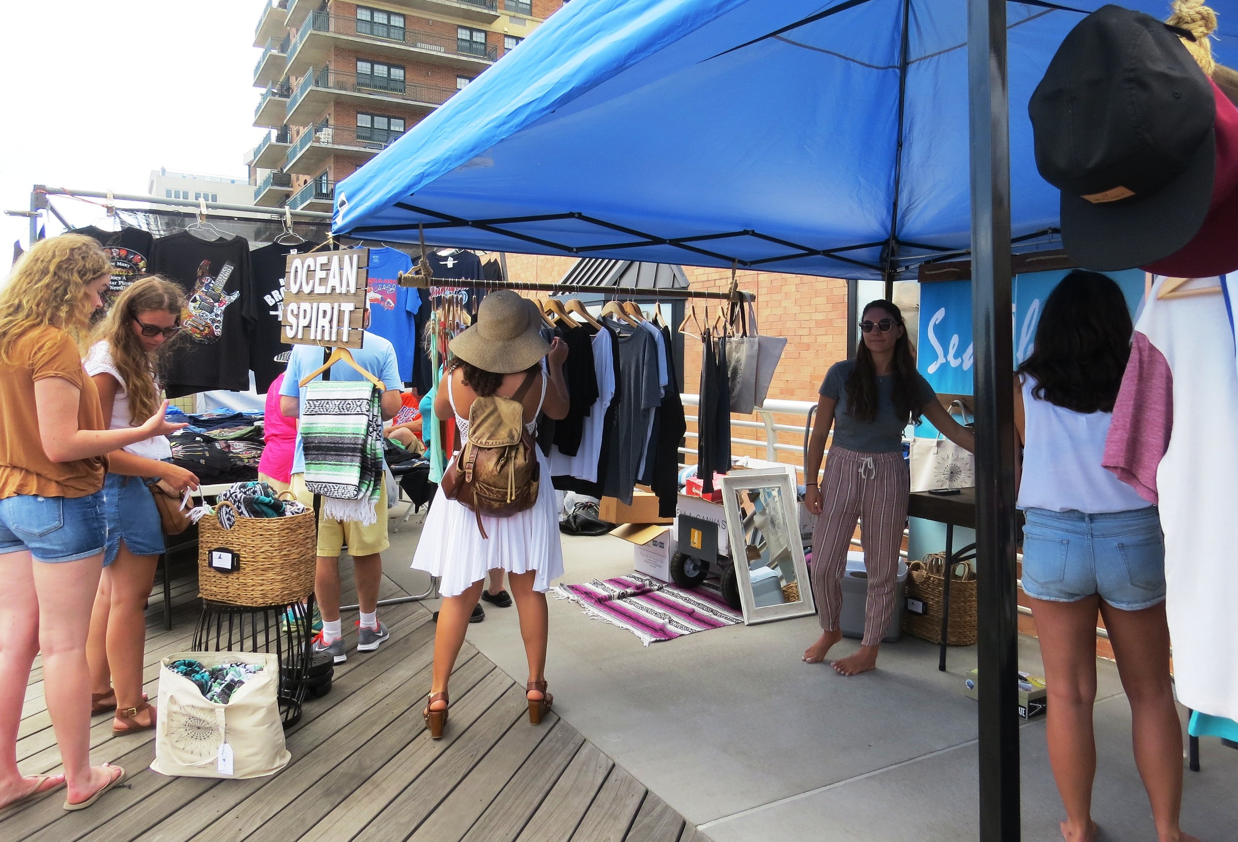 Customers shop the Ocean Spirit booth at the Long Beach Boardwalk Craft Fair.