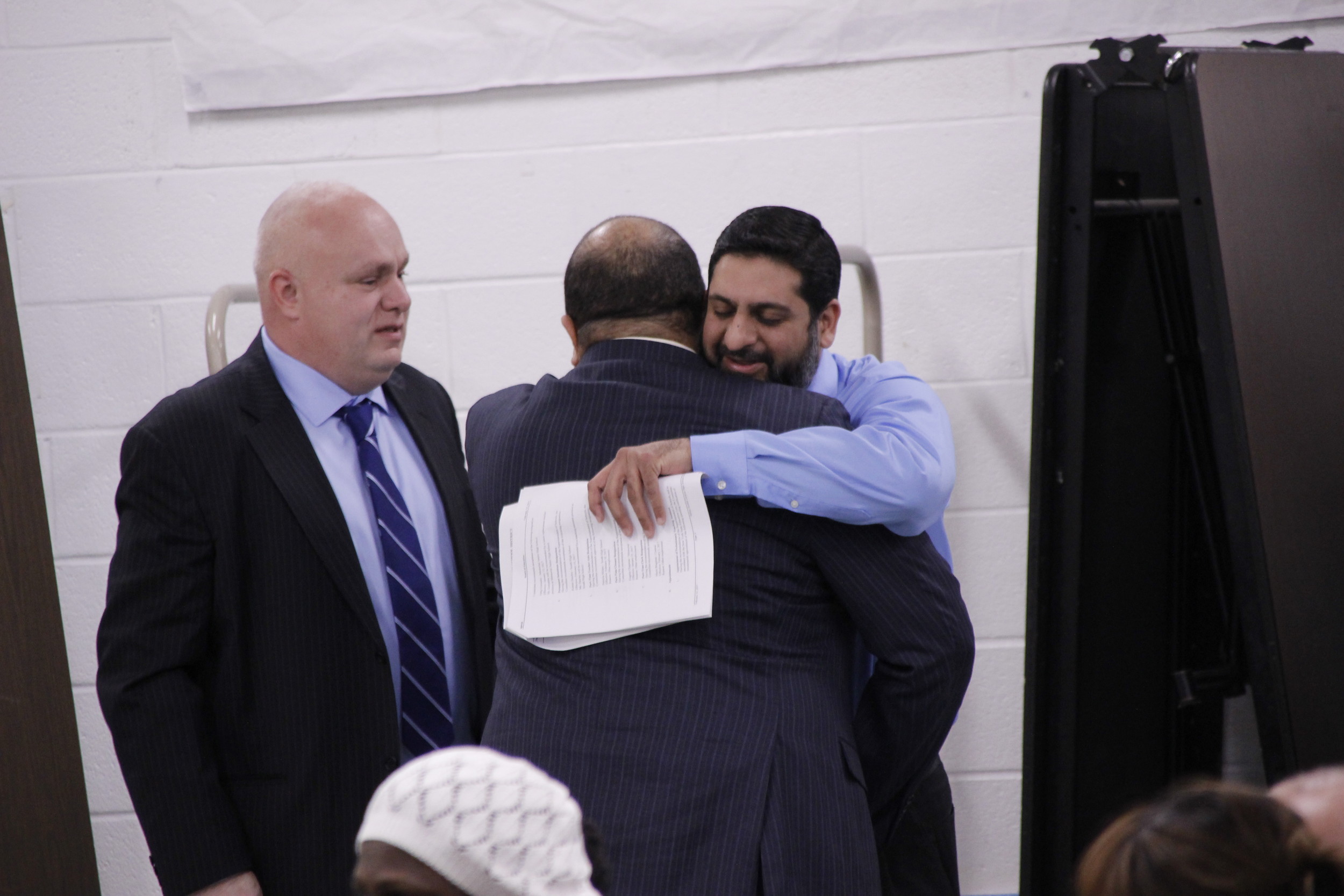 Karim Mozawalla, right, a trustee of Islamic Center of South Shore, embraced school board President Cristobal Stewart after the vote.