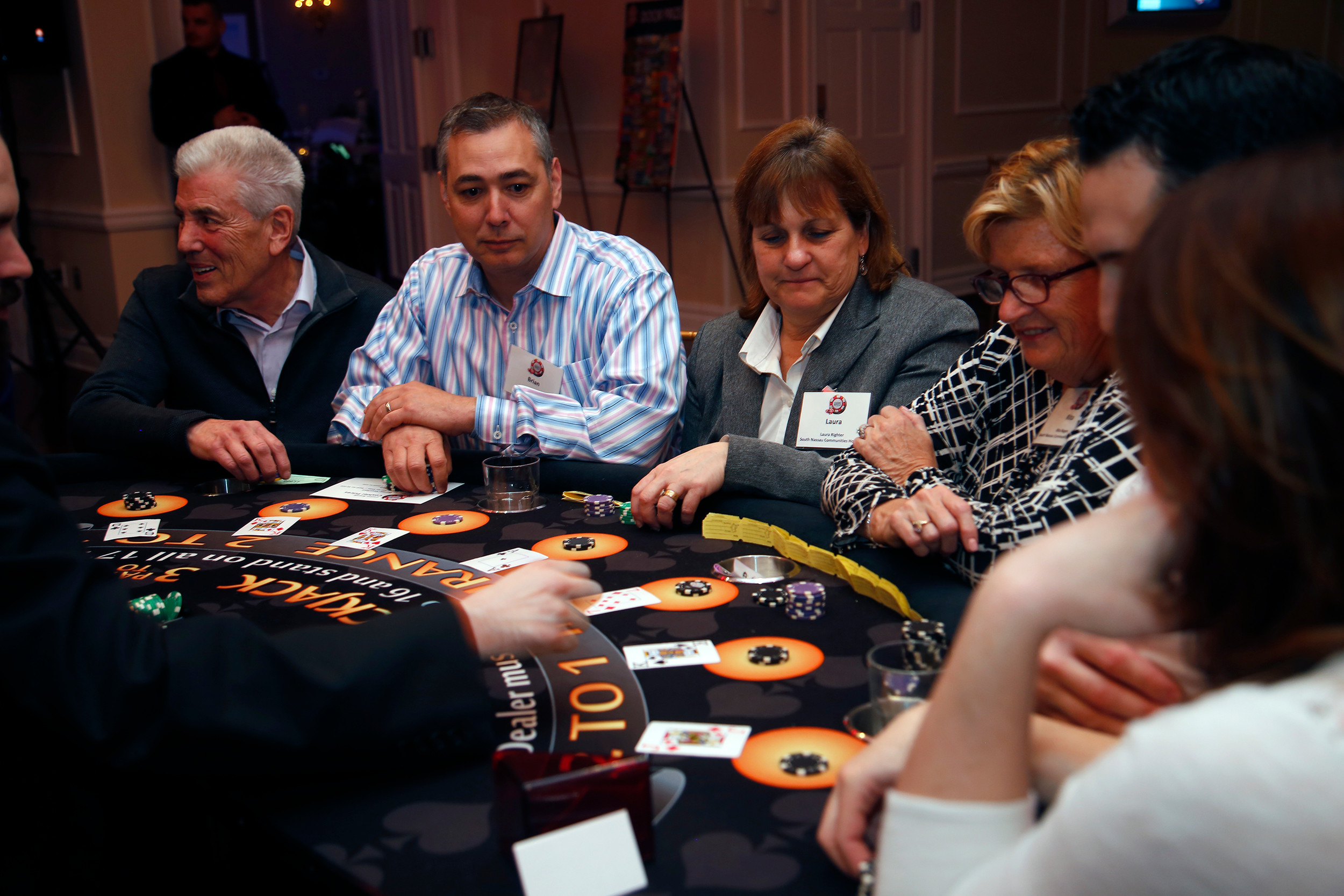Nelson Weisberg, Brian Marmor, Laura Rightor and Rita Regan wait for the dealer to flip his card at the blackjack table.