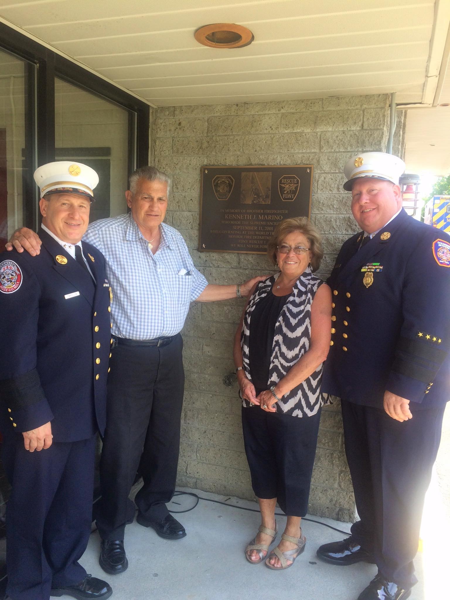 Oceanside Fire Department Chief Kevin Klein, right, and Assistant Chief Joseph Caroccia stood with the parents of fallen Sept. 11 first-responder Kenny Marino at a plaque dedication on June 10.
