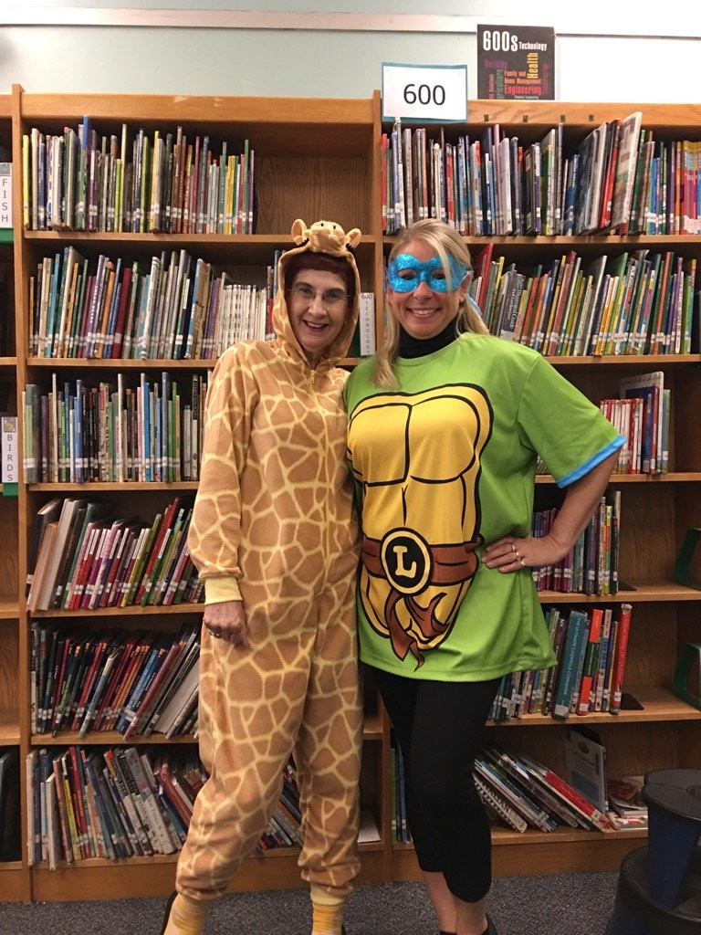 Susman, left, wore her giraffe onesie on Halloween. Her colleague at East Lake Elementary School, Lisa Gennardo, and her students know about her collection.