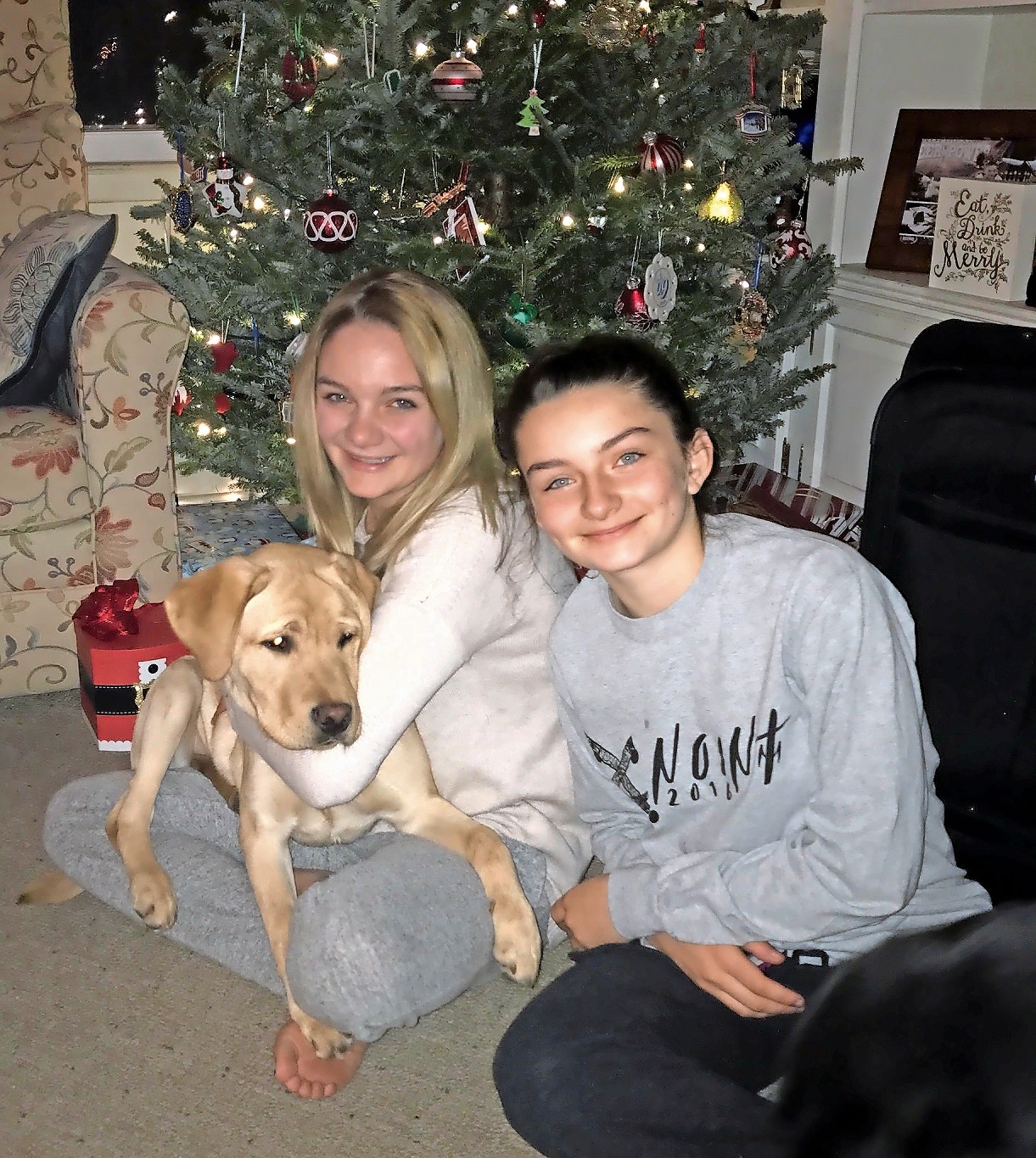 Morgan and Meredith Kass opened Christmas presents with their new Canine Companions dog, Zinger, in December.
