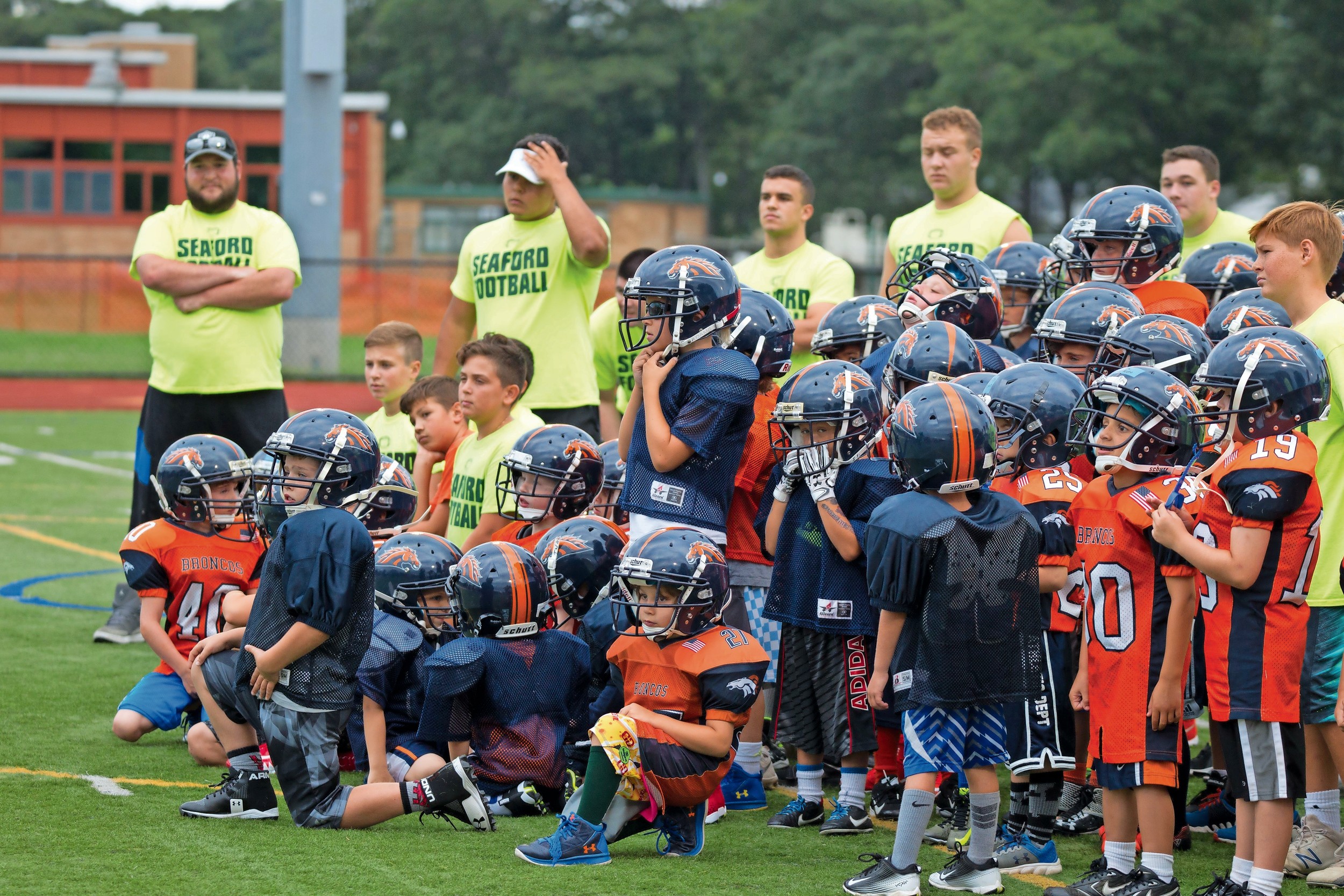 Seaford High School coaches and players taught youth players from the Long Island Broncos about football and community pride at the Never Quit Football Clinic on July 25.