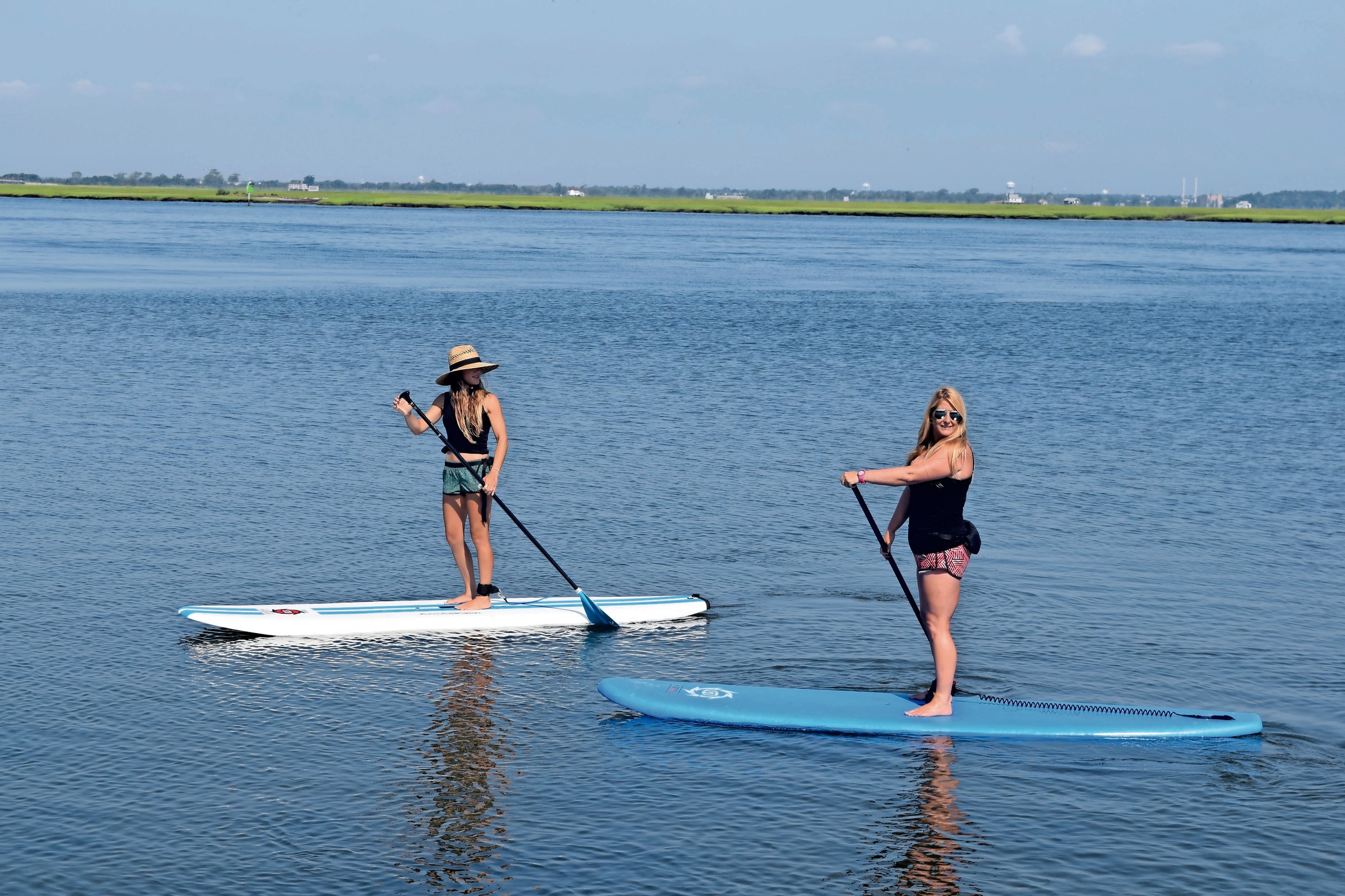 Jennifer Hanono, left, and Nicole Glasser paddled out at Jones Beach Field 10 to practice yoga.