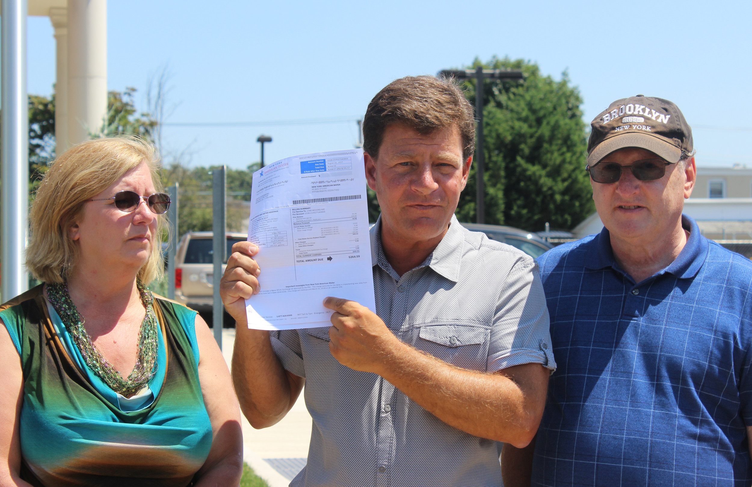 Long Island Clean Air Water and Soil co-director Dave Denenberg, center, showed the Herald his July water bill, half of which went to pay New York American Water's property taxes.