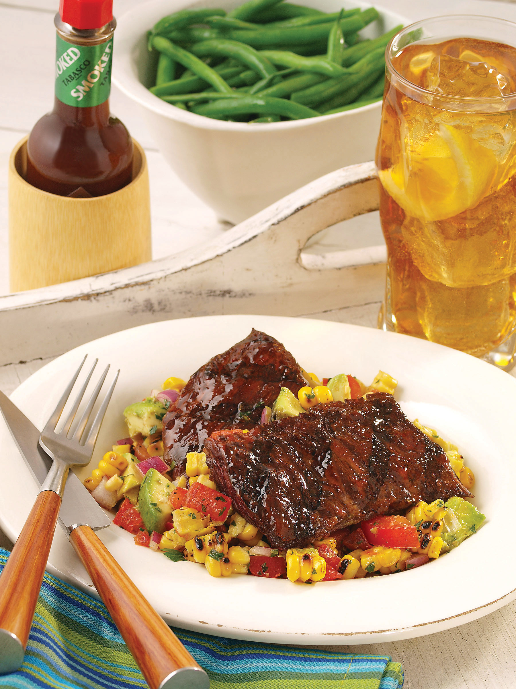 A quick and easy chipotle marinated grilled skirt steak will spice up any gathering. Pair it with a roasted corn salad that embodies the fresh flavors of the season — a mixture of corn, tomato, red onion, basil, and avocado.