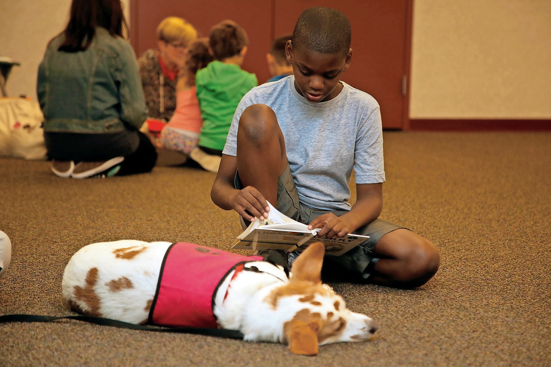 Aaron Stewart, 11, enjoyed a book as his canine friend, Chelsea, listened.