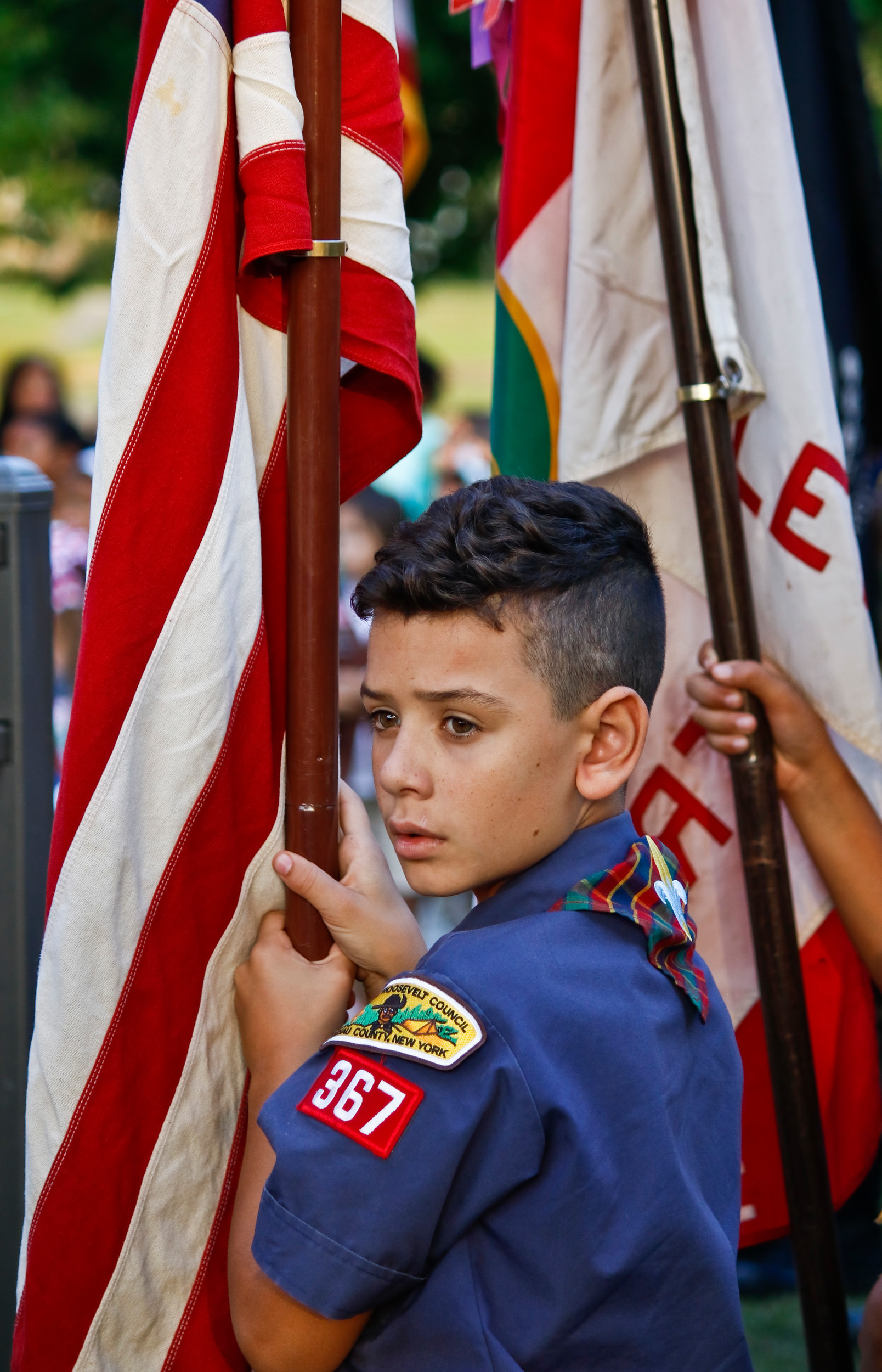 Joining the American Legion, VFW, Girl Scouts and other Boy Scouts, 10 year old Logan Thomson carried the American flag during the presentation of colors and took up his spot as the groups surrounded the memorial at Hendrickson Park.