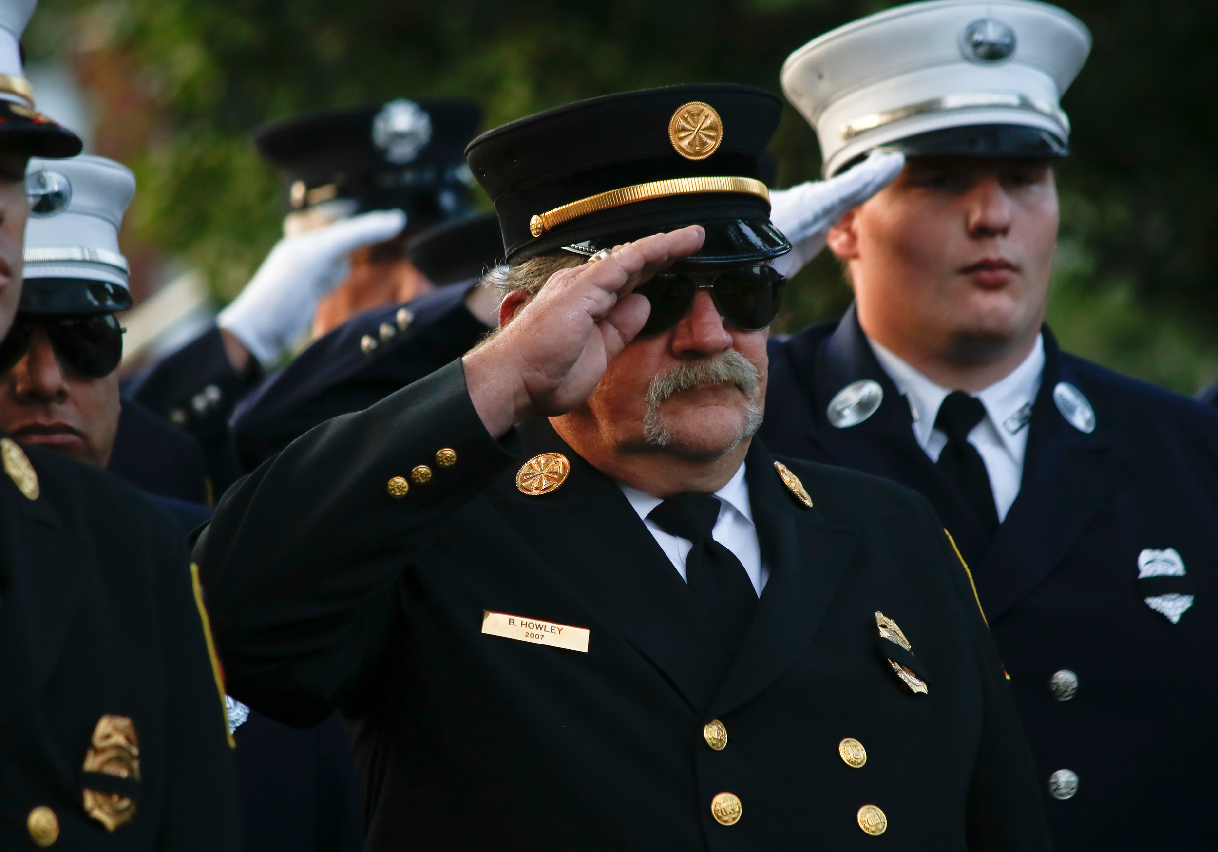 Brian Howley, center, along with the rest of the fire department, saluted during the playing of taps.