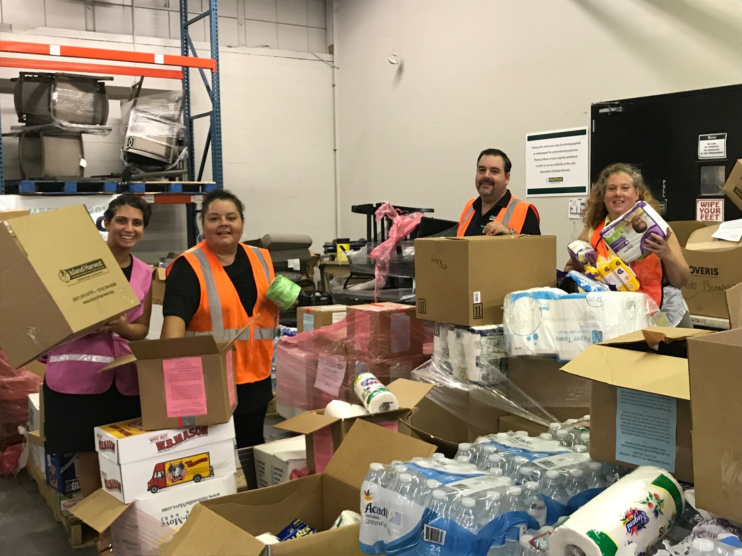 Island Harvest Food Bank employees Elizabeth Notarbartolo, far left, Migdalia Otero, Jeremy Waite and Hillary Hess sorted and packed donated goods on Sept. 27 to be shipped to Puerto Rico.
