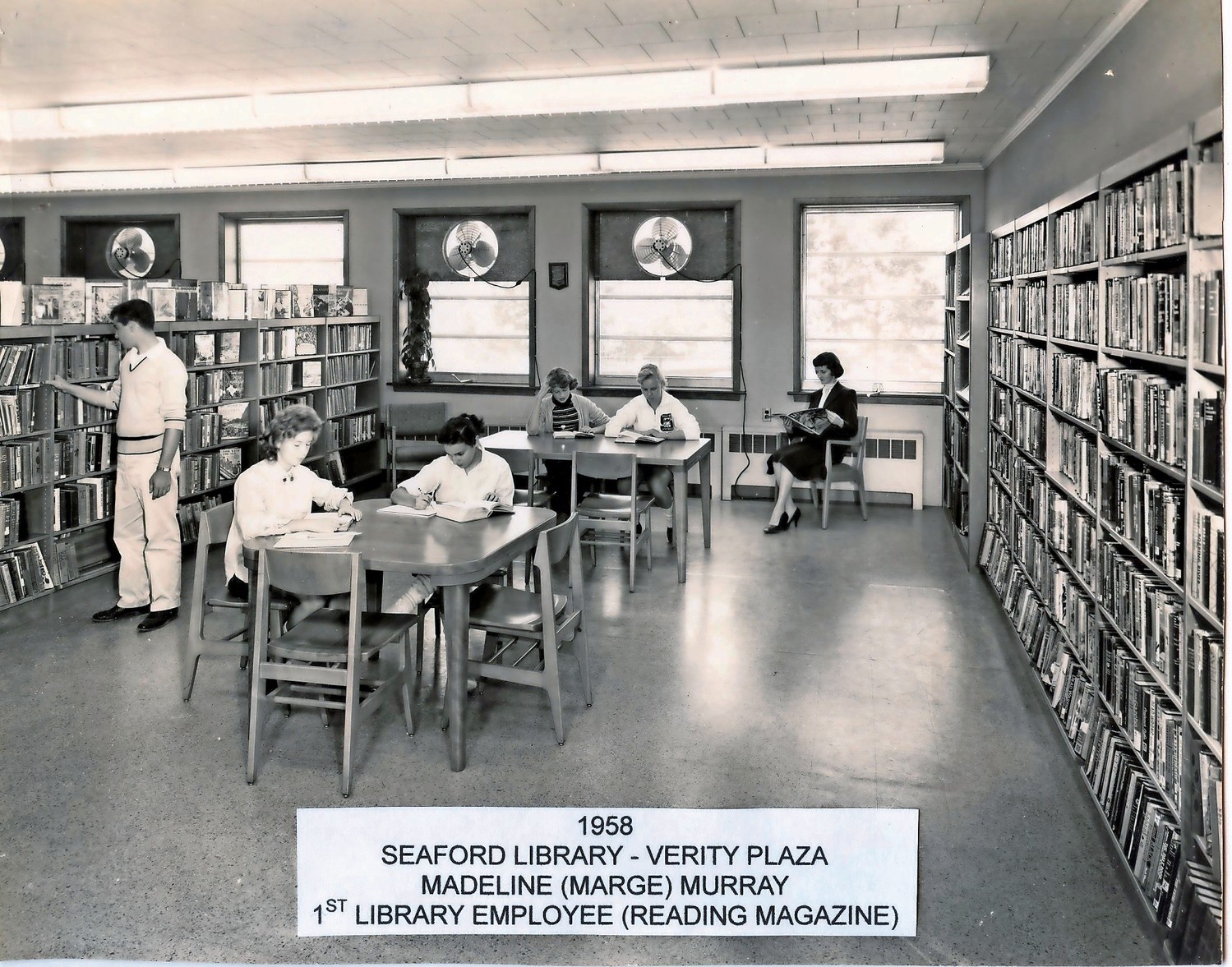 Madeline Murray, far right, the first Seaford Library clerk, read a magazine in the original building, at Verity Plaza, in 1958.