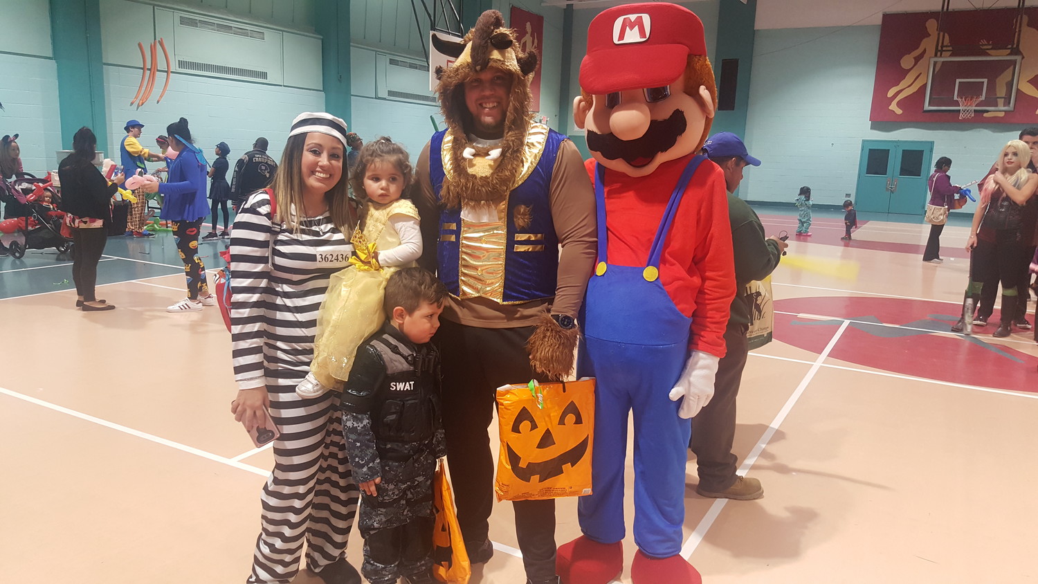 The Mufson family from Baldwin, Michelle, left, Aubrey, Jackson, and Sean, left were all smiles with Mario Bros. character during the Freeport Recreation Center annual Halloween Parade last Tuesday.