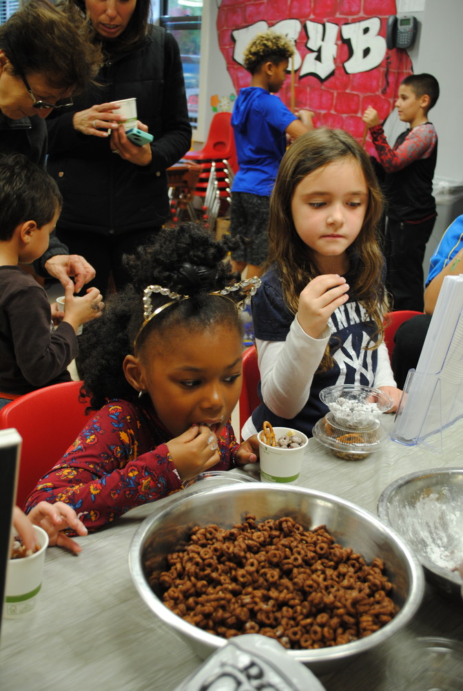 Ma’zeona Peterson, 6, and Maya Miller, 6, made snacks with Glen Cove Hospital’s Chef Manager Claire Fastenau, who came to the Youth Bureau for its Lights on Afterschool event on Oct. 27.