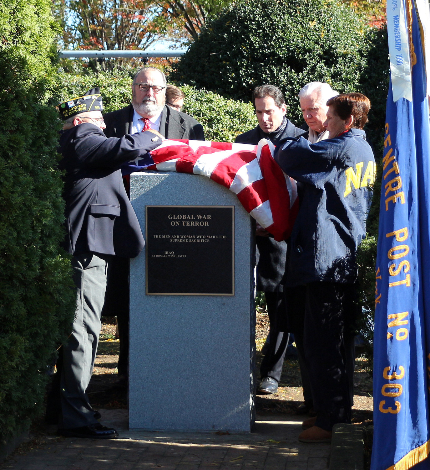 Frank Colon Jr., commander of Rockville Centre American Legion Post 303, left, and Marianna Winchester, Gold Star mother of the late Marine First Lieutenant Ronald Winchester, right, unveiled a monument last Saturday outside the Recreation Center.